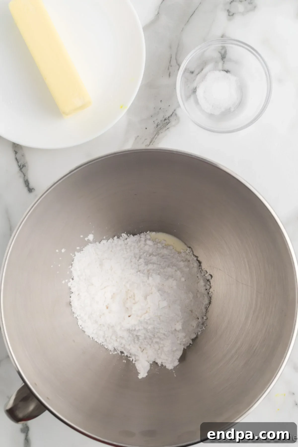 Creamy Mint Delights 5 A bowl showing powdered sugar thoroughly combined with butter and other wet ingredients, forming a thick, smooth dough.