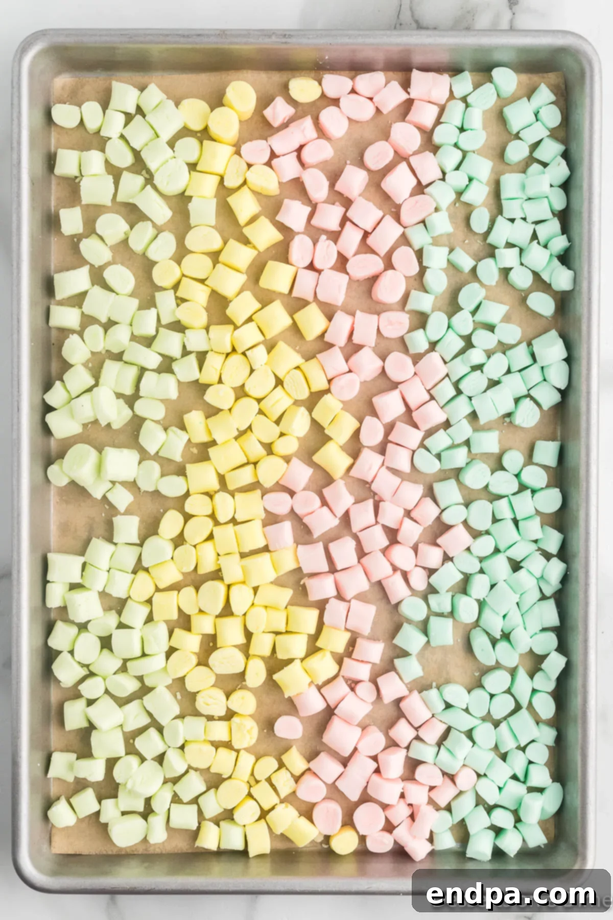 Creamy Mint Delights 8 Colorful butter mints arranged neatly on a cookie sheet lined with parchment paper, allowing them space to dry out properly.