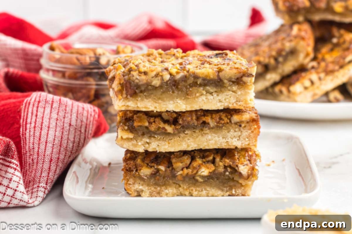 Pecan Pie Bars stacked beautifully on a white plate, showcasing their golden crust and rich, nutty topping, ready to be enjoyed.