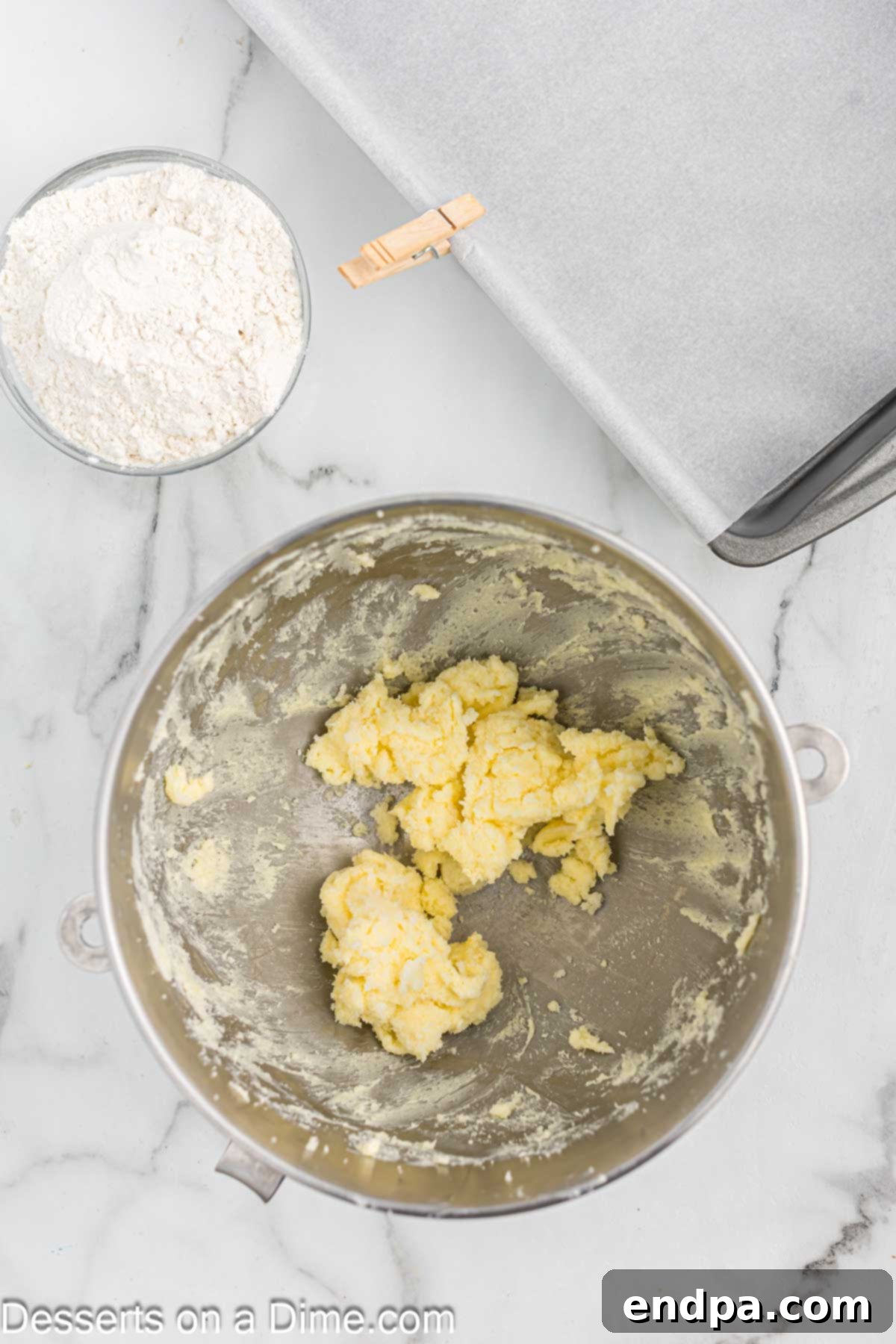 Softened butter being creamed with granulated sugar in a stand mixer, forming the base for the shortbread crust.
