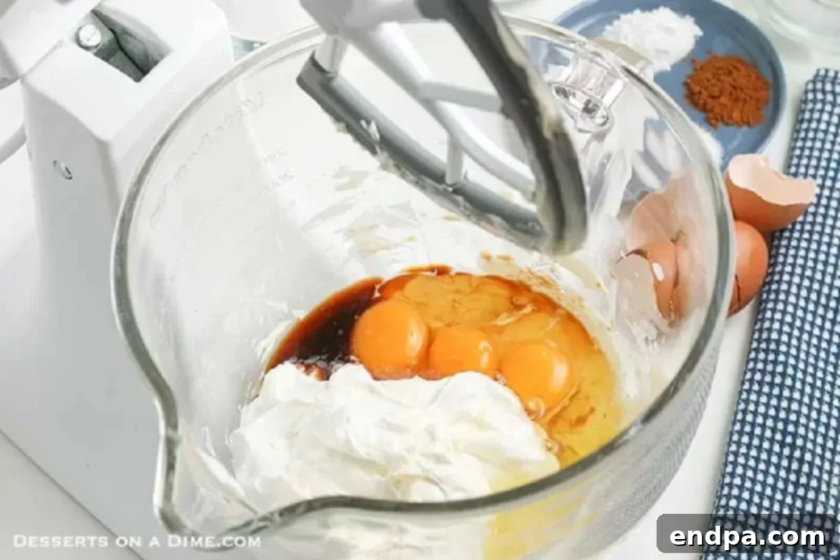 A large mixing bowl containing creamed butter, eggs, and vanilla extract, ready for further mixing to create the coffee cake batter.