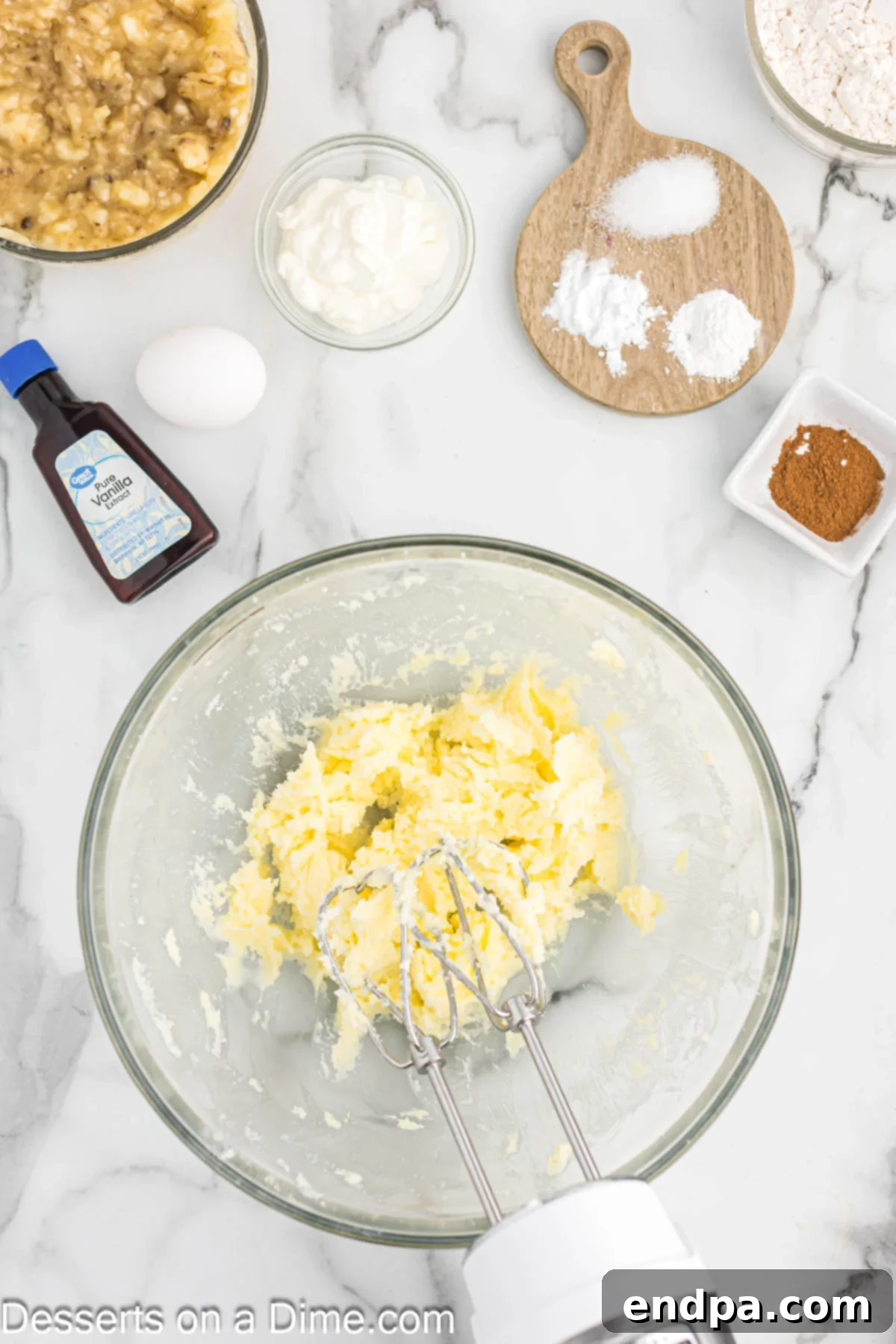 A mixing bowl containing softened butter and granulated sugar, ready for creaming with a mixer.