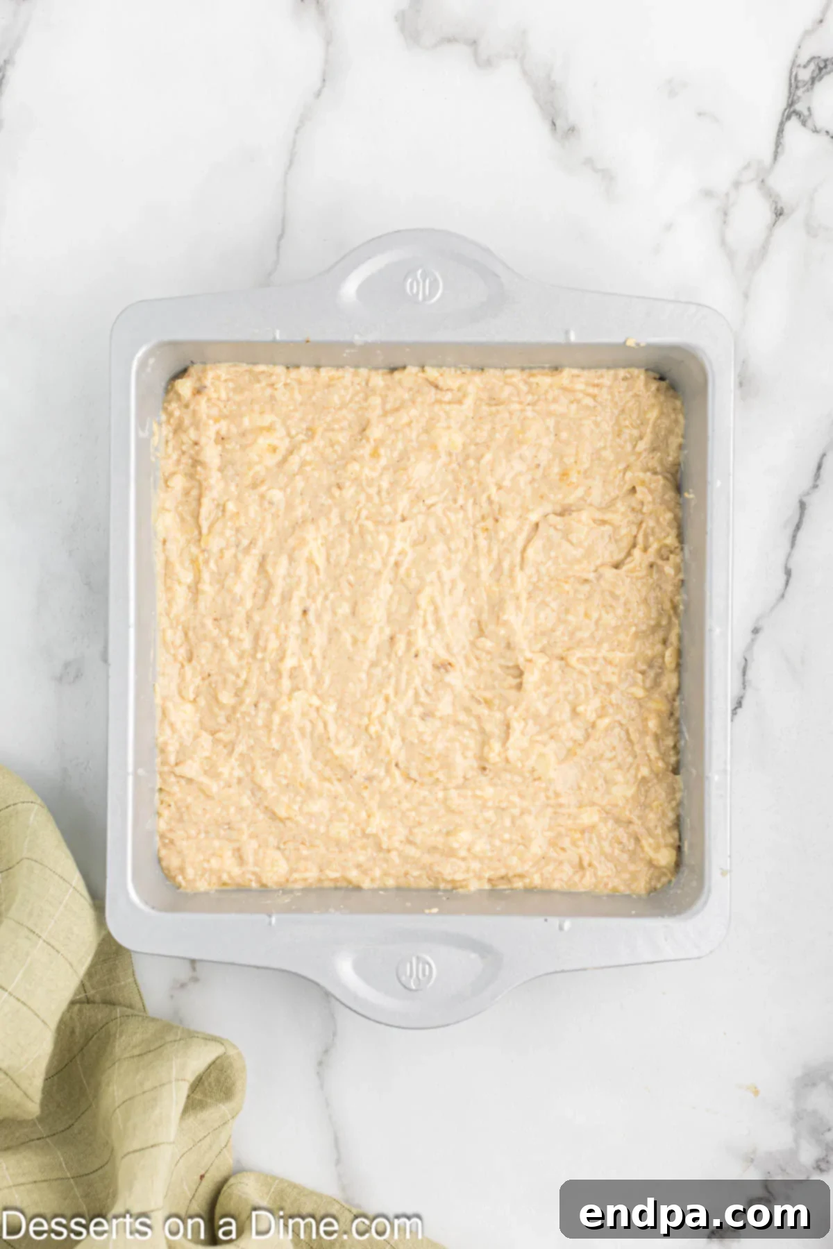 The smooth banana coffee cake batter has been poured evenly into the prepared 9x13 inch baking dish.