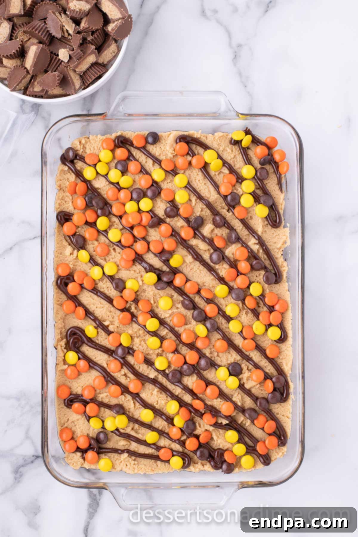 Decadent Reese's Peanut Butter Brownies 11 Chocolate drizzle and Reese's candies spread over the frosted brownies.