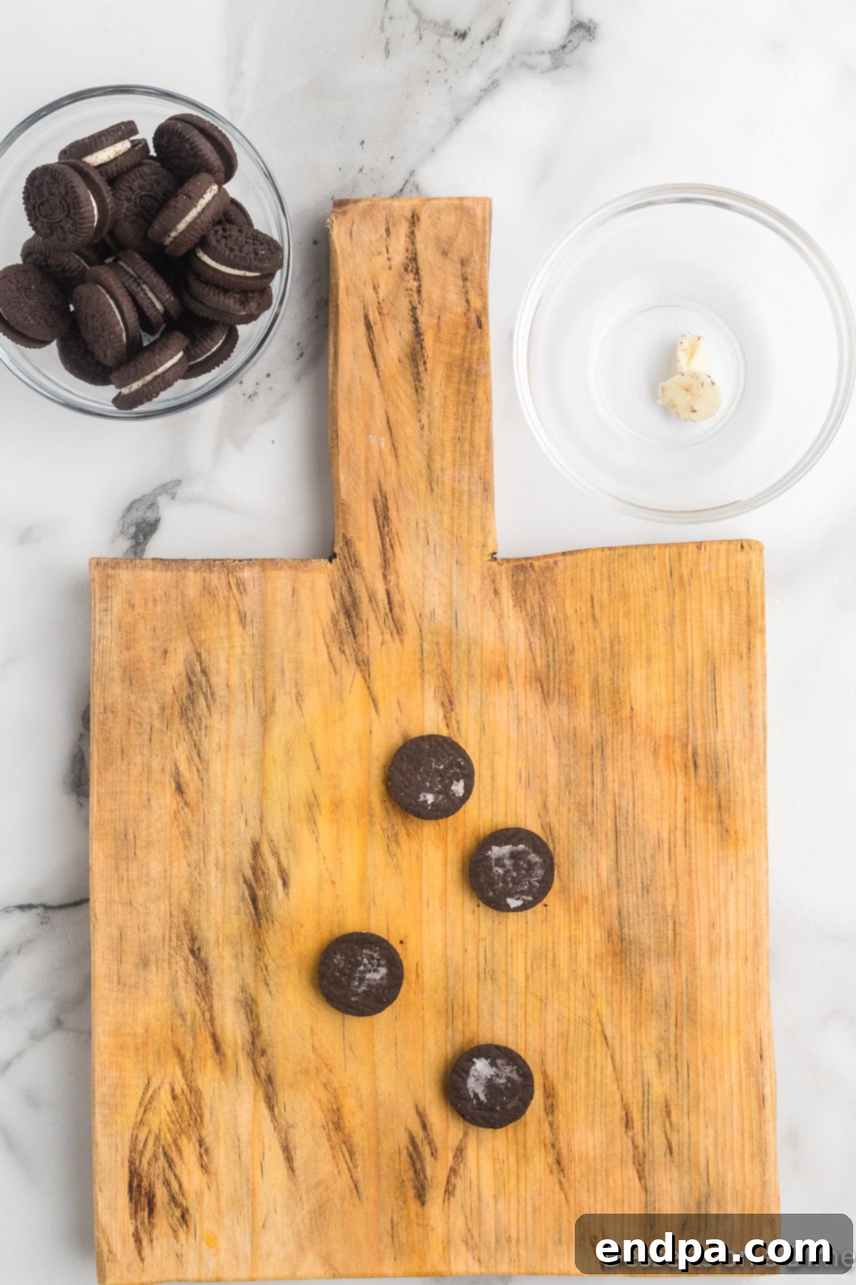 Mickey's Magical Oreo Treats 5 Mini Oreo cookies neatly separated into halves on a surface, with the cream filling removed, ready for assembly into Mickey's ears.