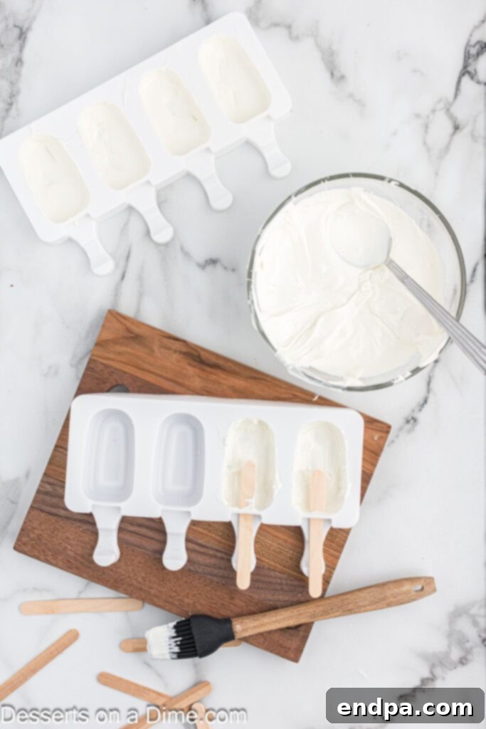 Dessert Pops 5 Popsicle molds with melted chocolate being spread into the cavities for the first layer.