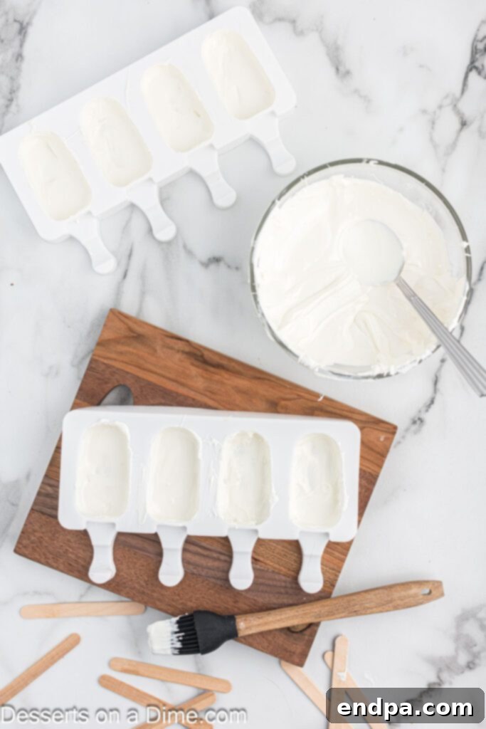 Dessert Pops 6 A bowl of melted candy melts next to popsicle molds with chocolate coating, and a popsicle stick.