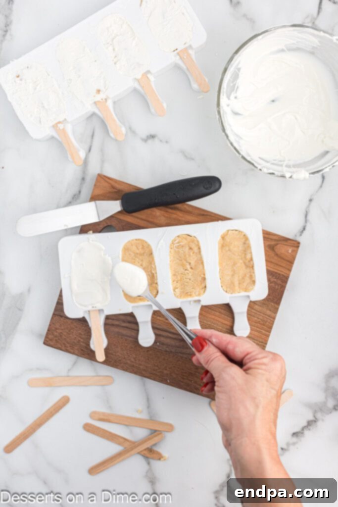 Dessert Pops 8 Melted candy melts being spread thinly over the top of the cake mixture in the molds.