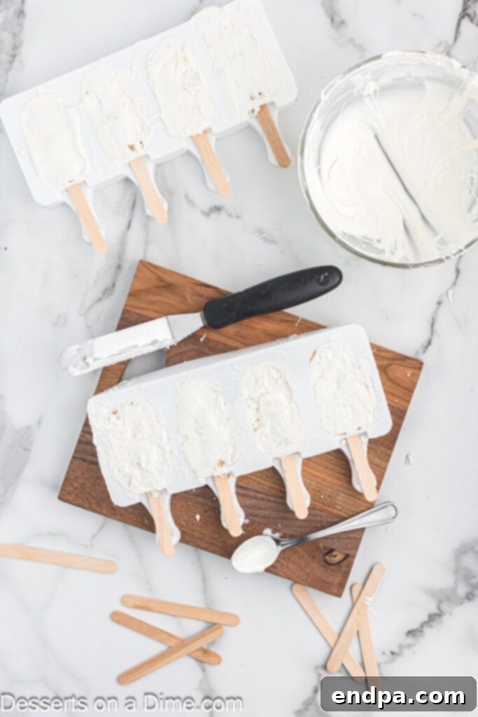 Dessert Pops 9 An offset spatula scraping excess chocolate from the top of the cakesicle molds.