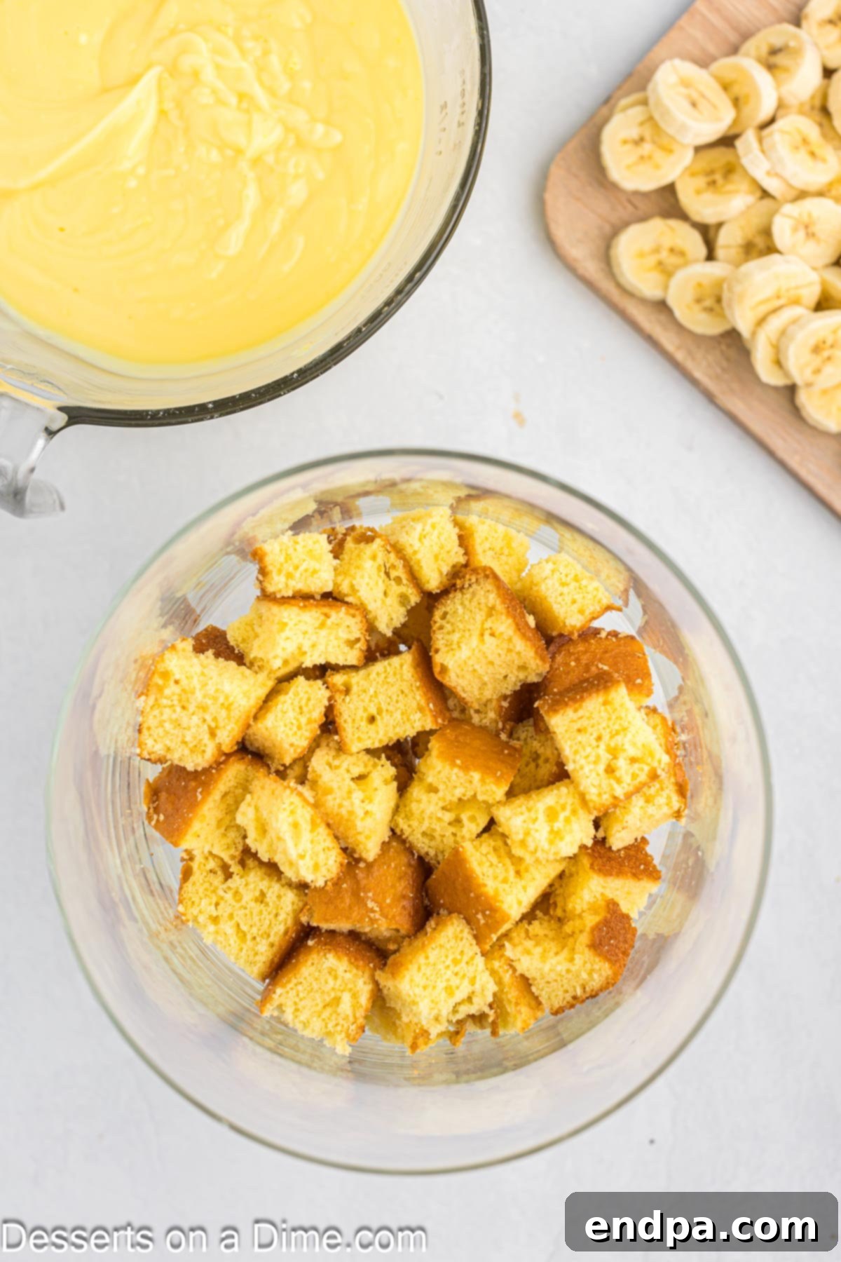 A large mixing bowl filled with bite-sized cubes of cooled cake, ready for layering.