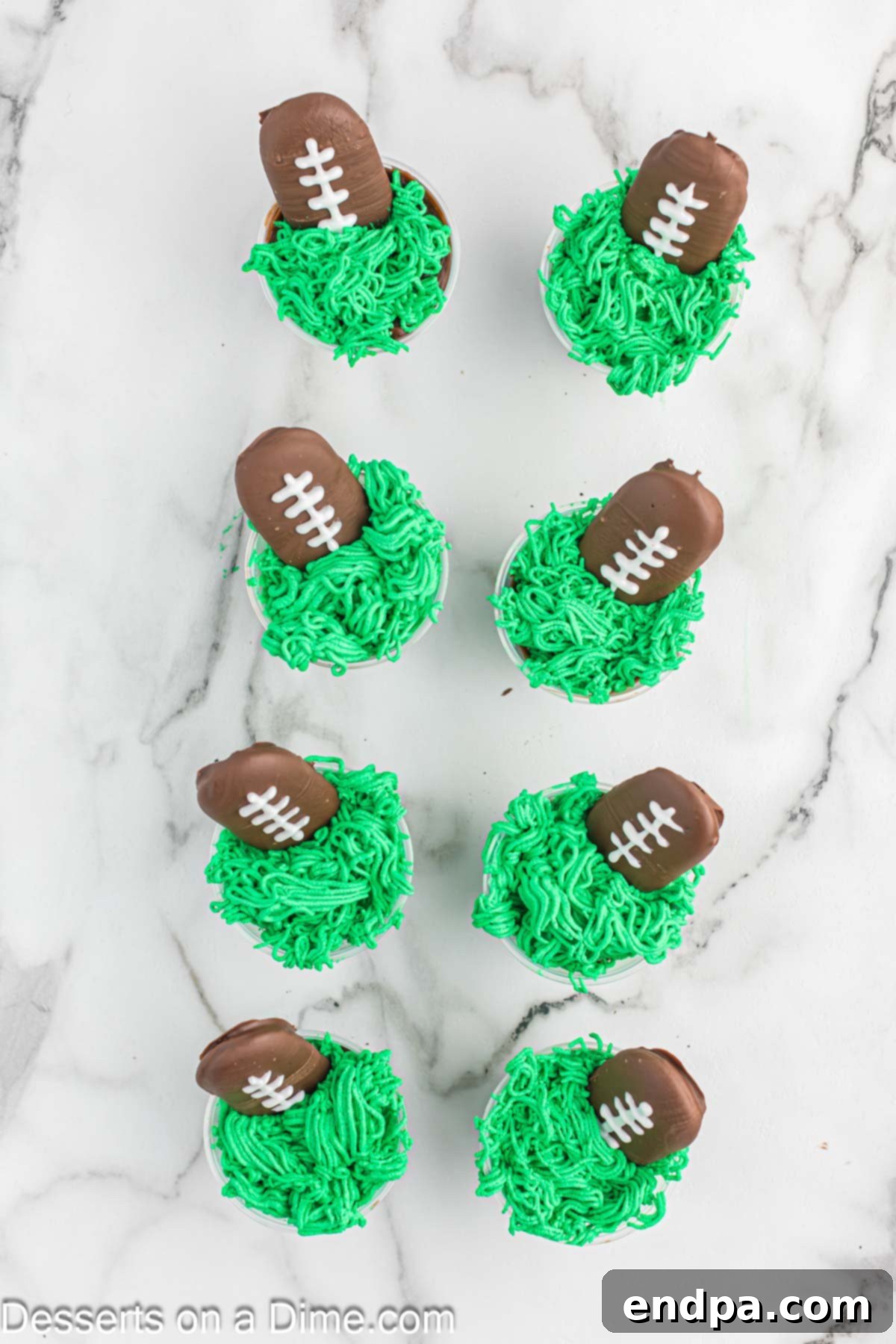 Green whipping cream and football cookie on top of each cup.