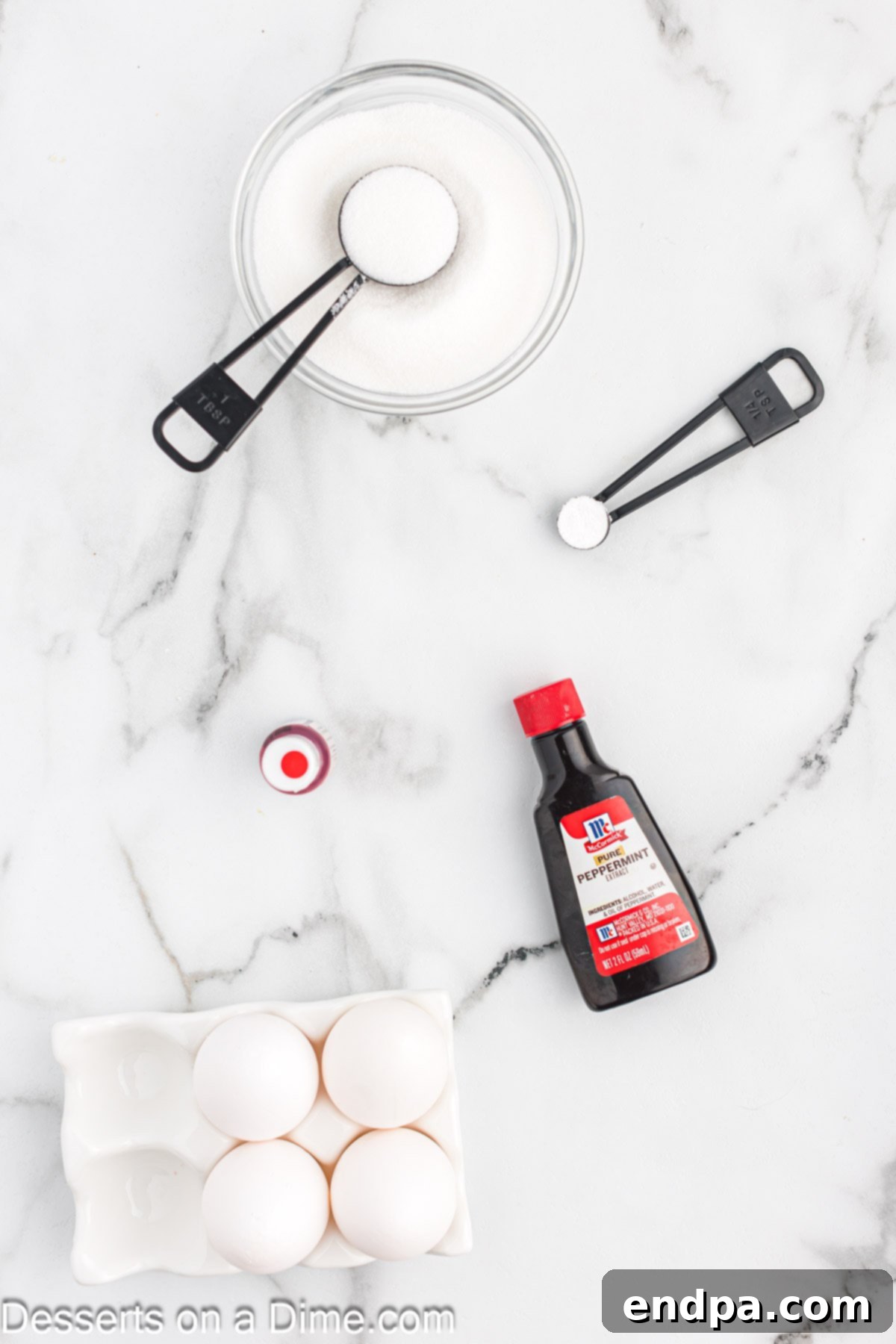 Peppermint Cloud Kisses 3 Essential ingredients for peppermint meringues including sugar, cream of tartar, peppermint extract, and red food coloring.