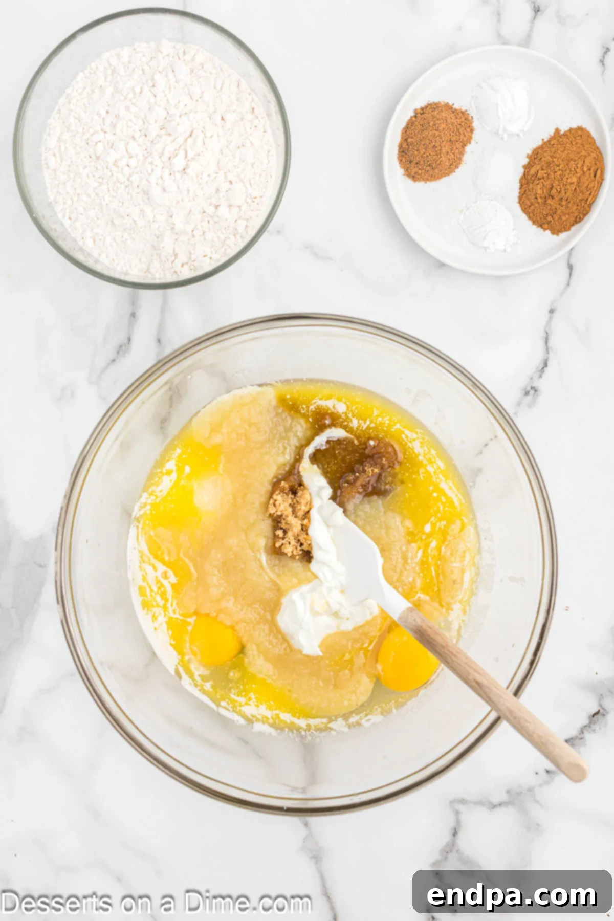 Bowl of melted butter, sugars, eggs, applesauce, and Greek yogurt.