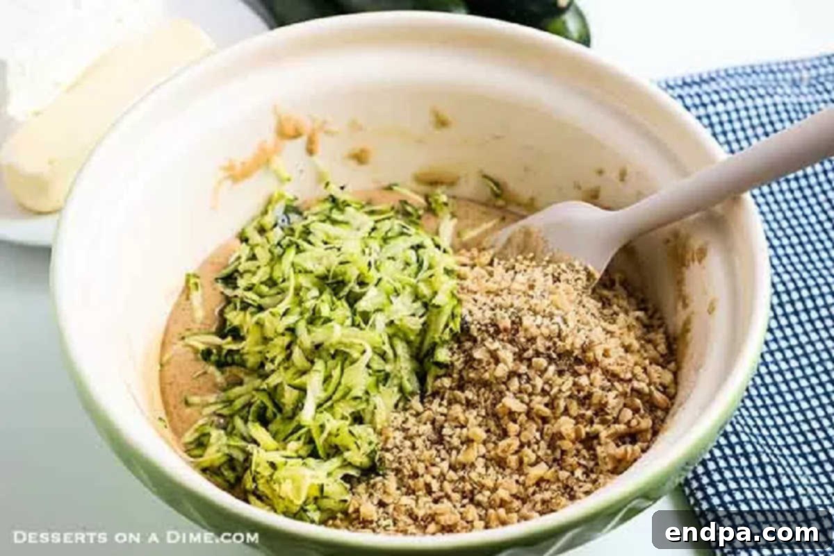 A large mixing bowl containing combined wet and dry ingredients for Zucchini Cake, showing a rich, smooth batter.