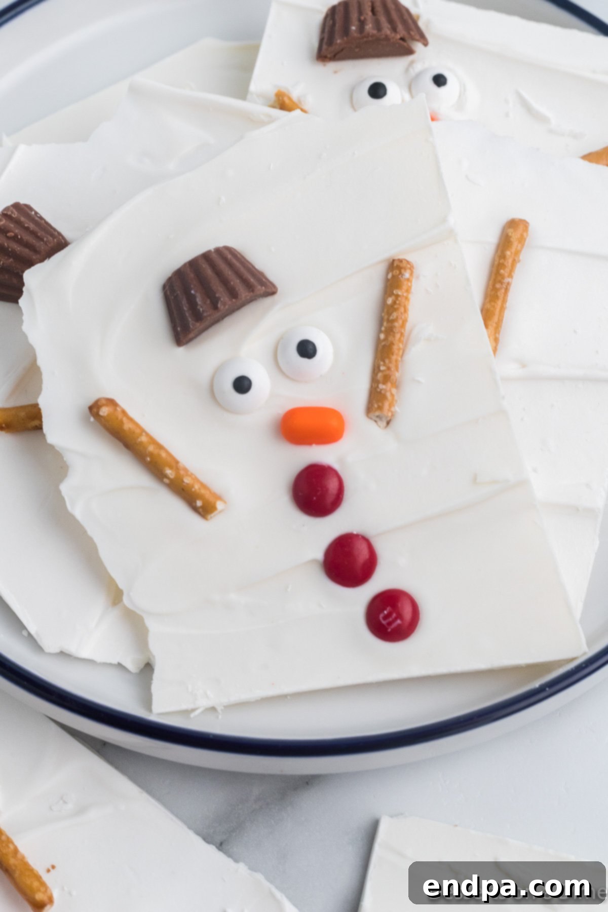 Frosty Meltdown Bark 2 Melted Snowman Bark broken into pieces, showcasing the whimsical snowman faces and colorful candies.