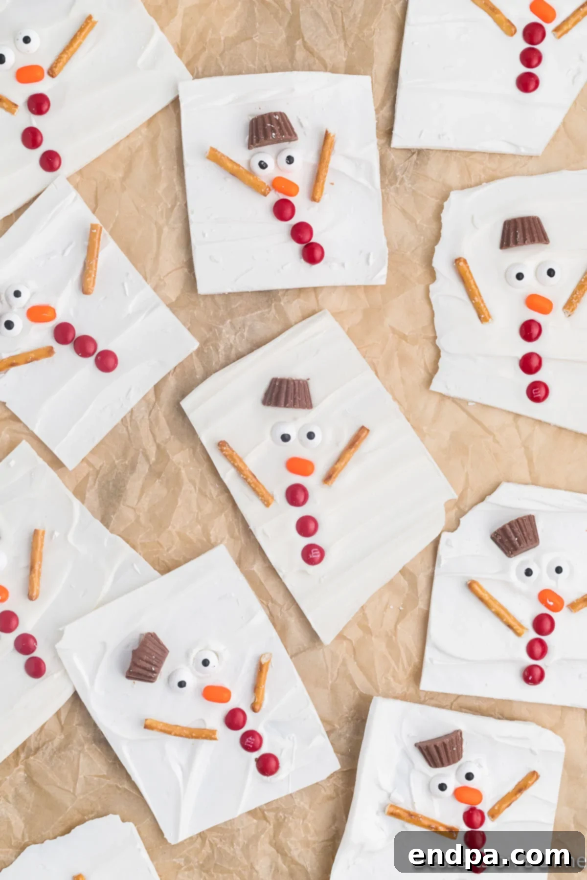 Frosty Meltdown Bark 10 Solidified chocolate bark being broken into irregular pieces, revealing the snowman designs.