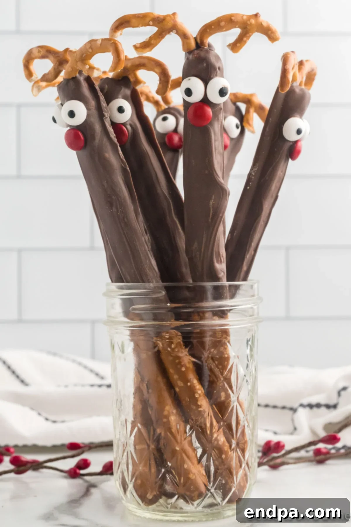 Collection of finished Reindeer Pretzel Rods displayed upright in a rustic mason jar, ready for gifting or serving.