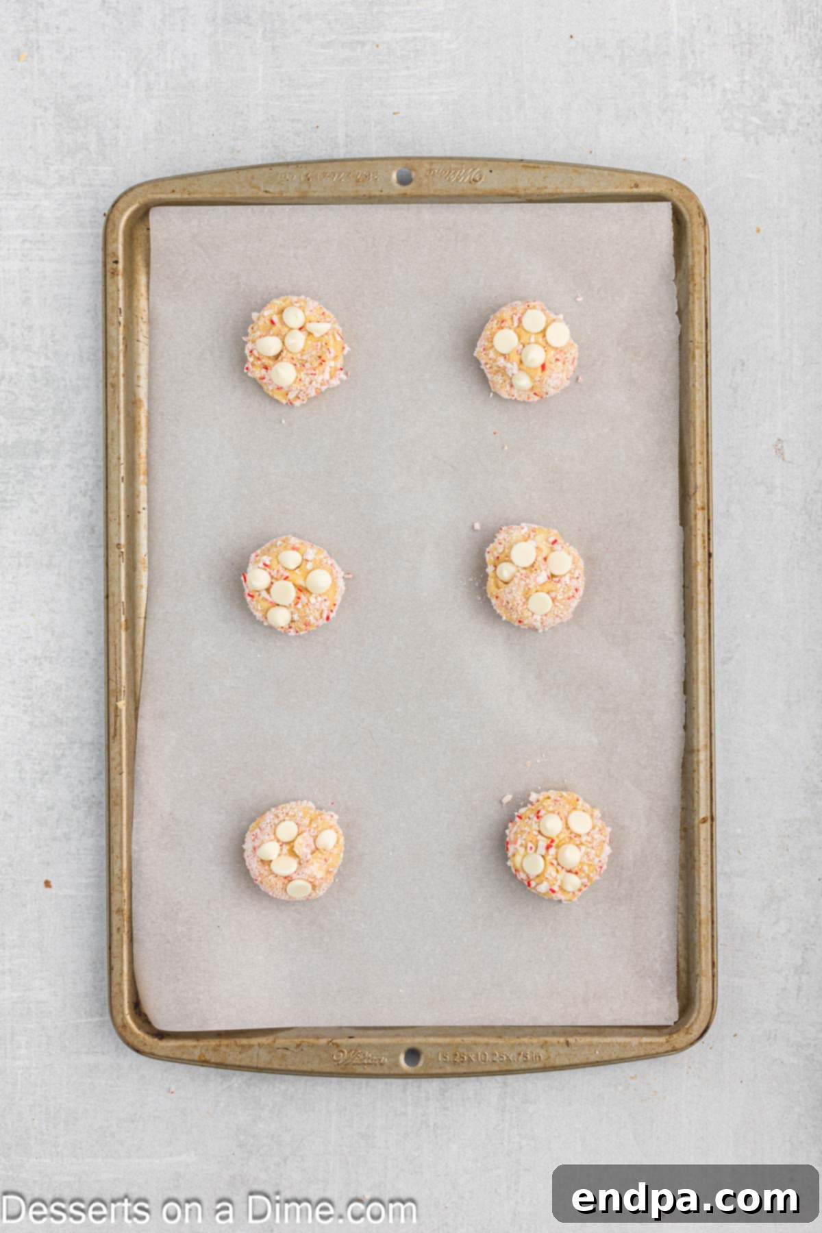 Peppermint White Chocolate Delights 9 Remaining chocolate chips added to dough balls on baking sheet.