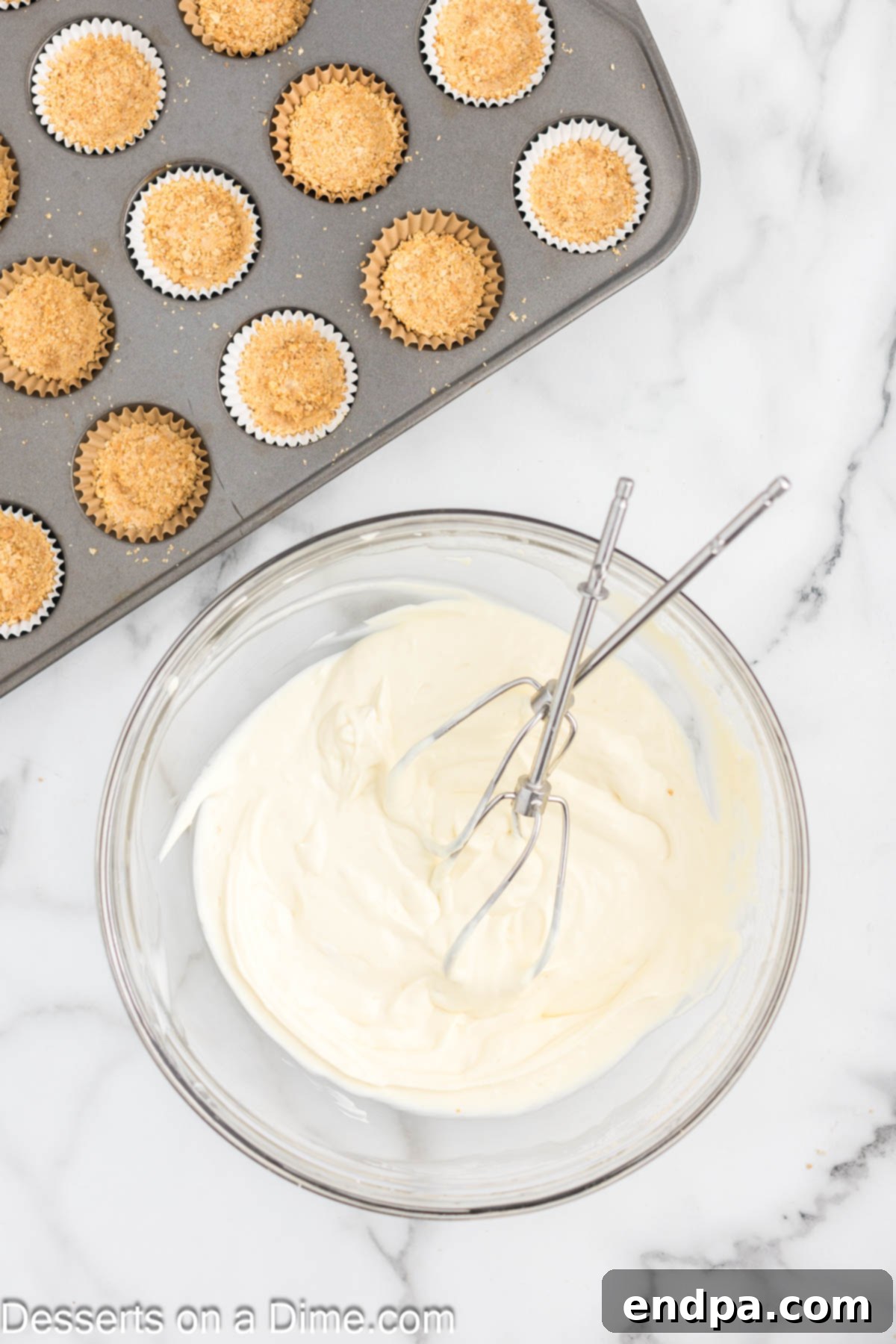 Bowl of smooth cheesecake filling, ready to be added to the crusts.