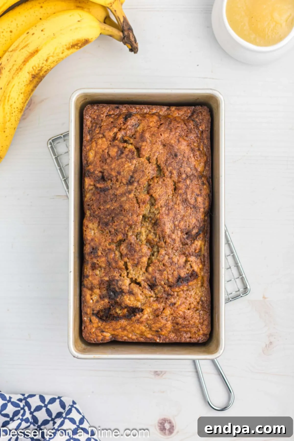 Freshly baked banana bread cooling in the loaf pan, golden brown and risen.