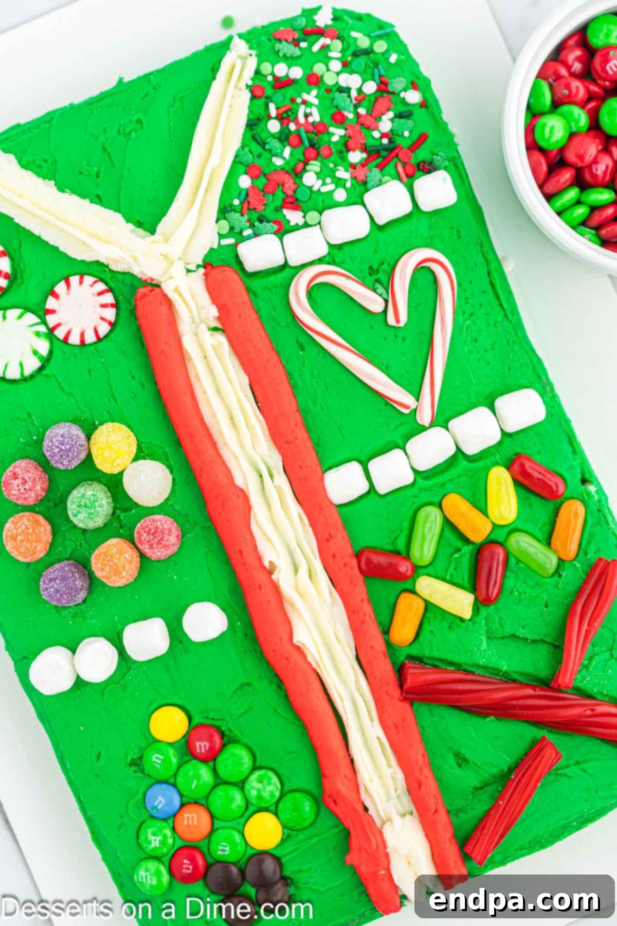 Gaudiest Garment Bake 11 Fully decorated Ugly Sweater Cake on a platter with a variety of colorful candy toppings and sprinkles.