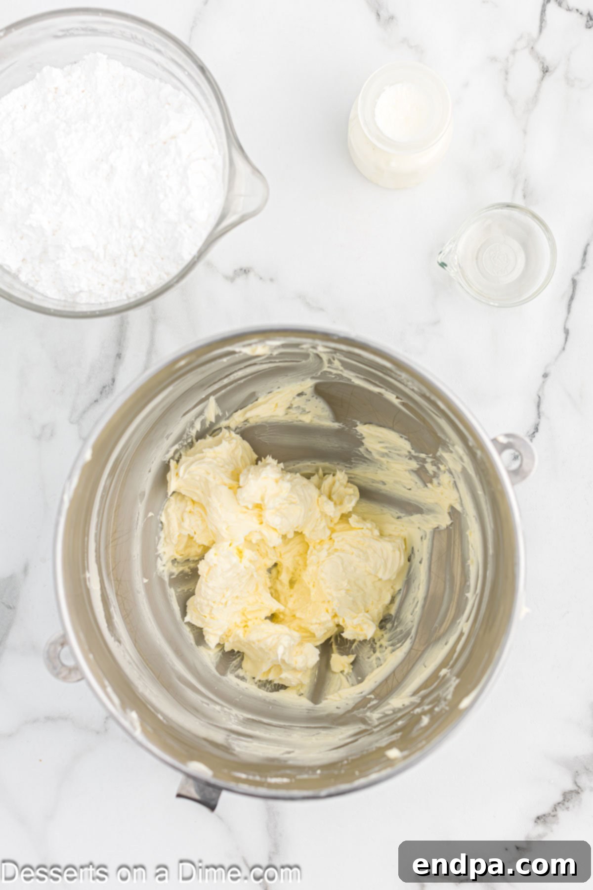 Gaudiest Garment Bake 5 Close-up of butter being creamed in a mixing bowl with an electric mixer.