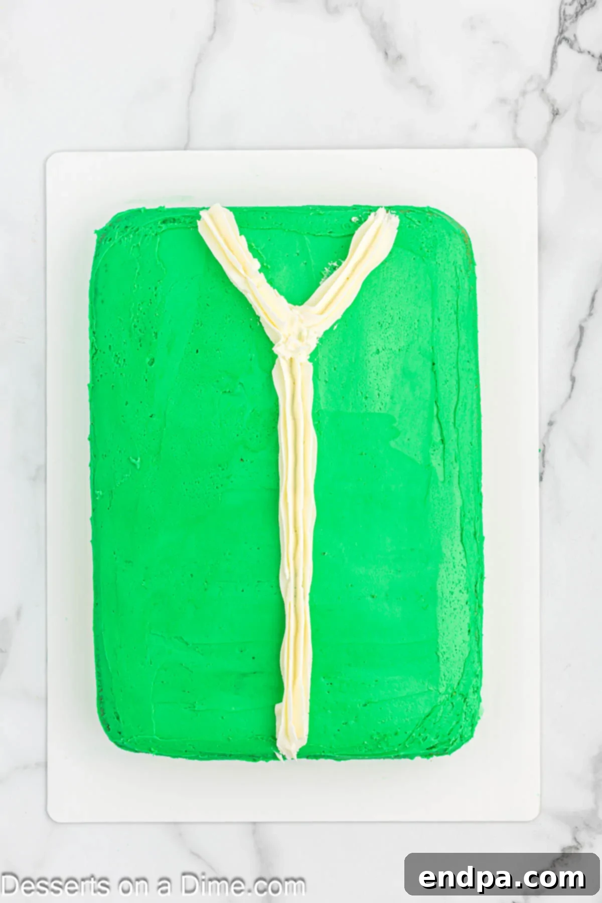 Gaudiest Garment Bake 9 White icing piped down the middle of the cake, forming a V-neck shape at the top.