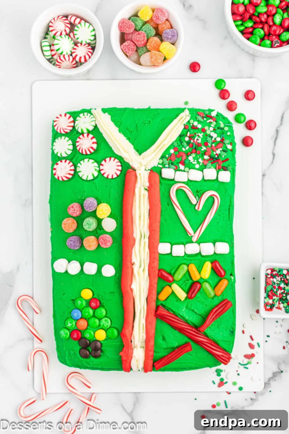 Gaudiest Garment Bake 10 Ugly Sweater Cake on a platter with initial candy decorations added to the V-neck and center line.