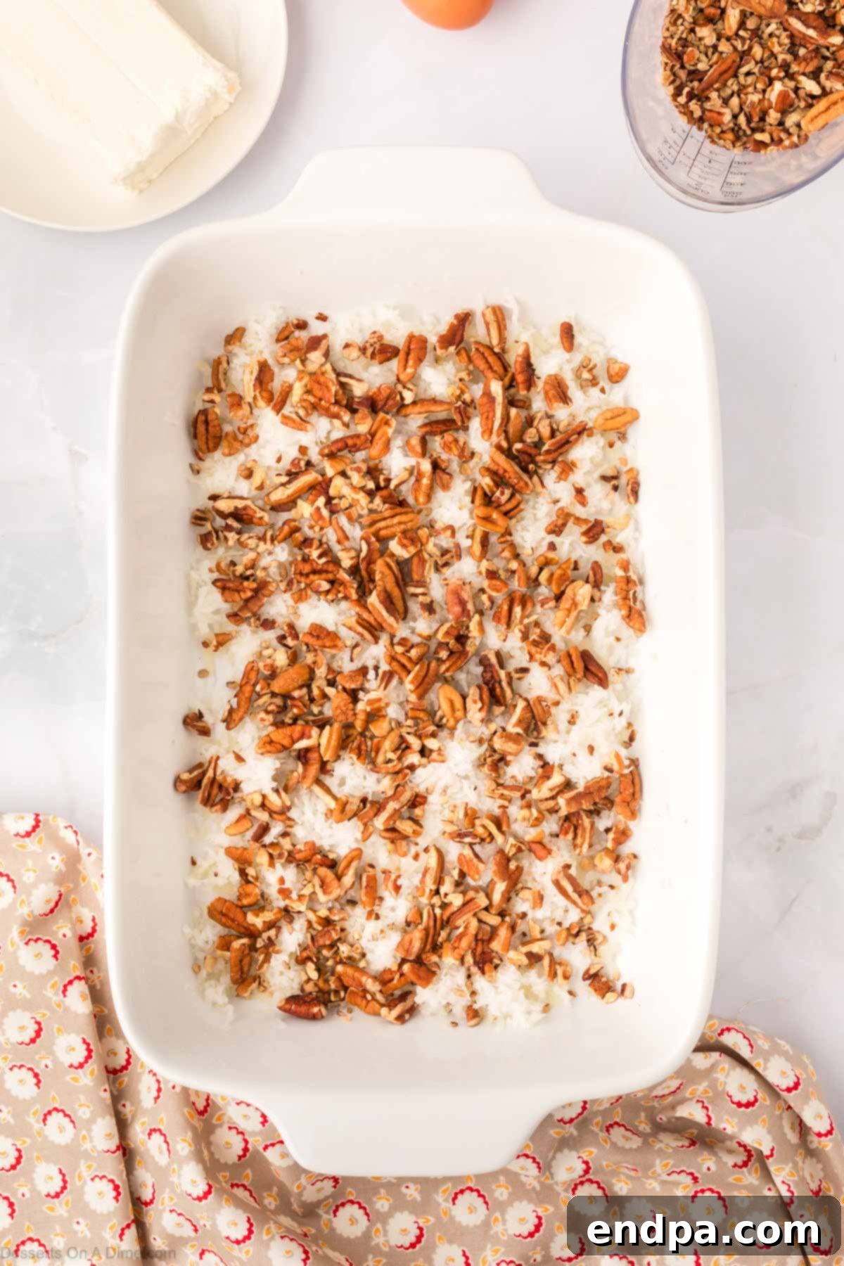 One-Pan German Chocolate Cake 4 Nuts and coconut layered in pan ready for cake batter.