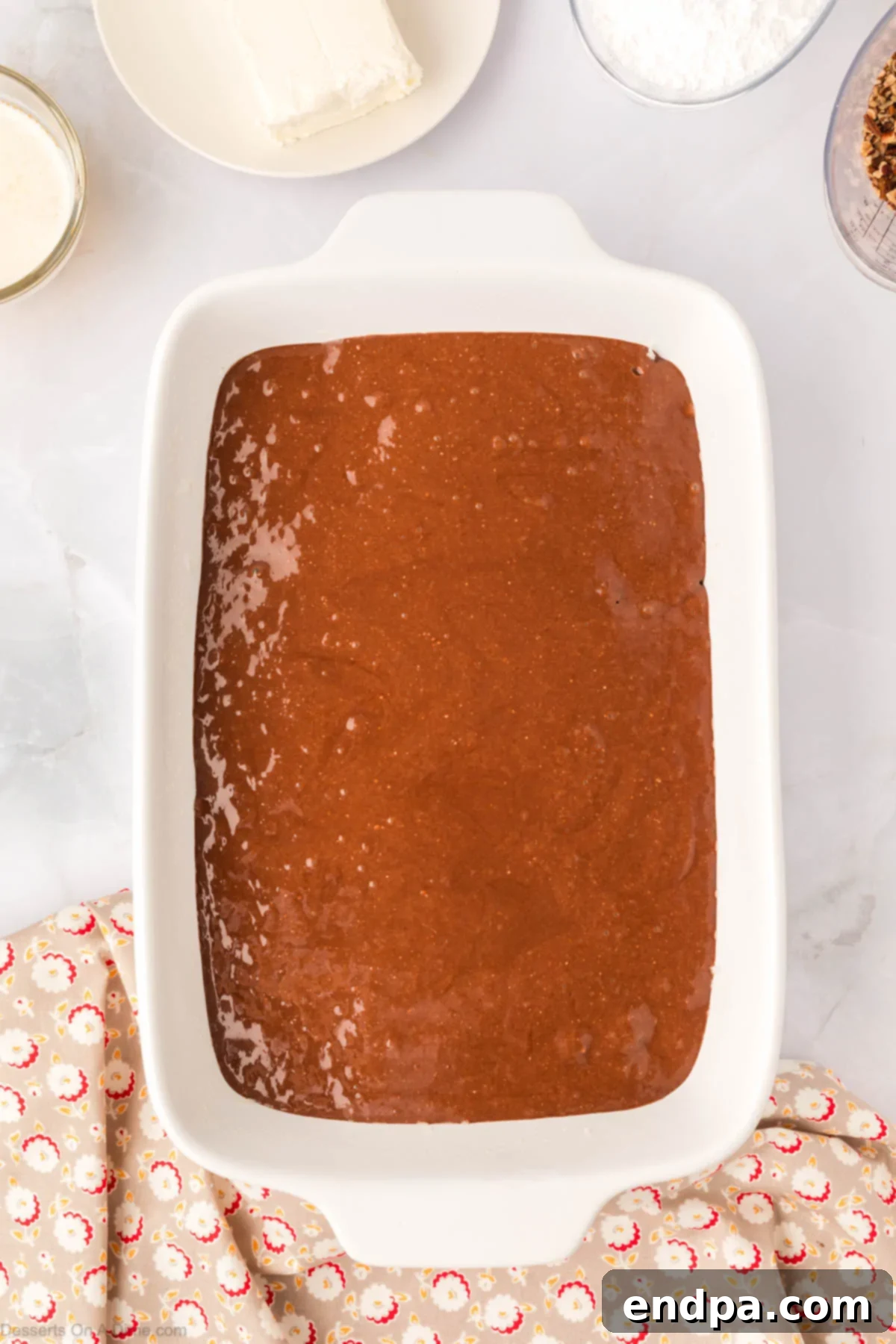 One-Pan German Chocolate Cake 5 Prepared cake batter poured over the pecan and coconut layer in the baking pan.