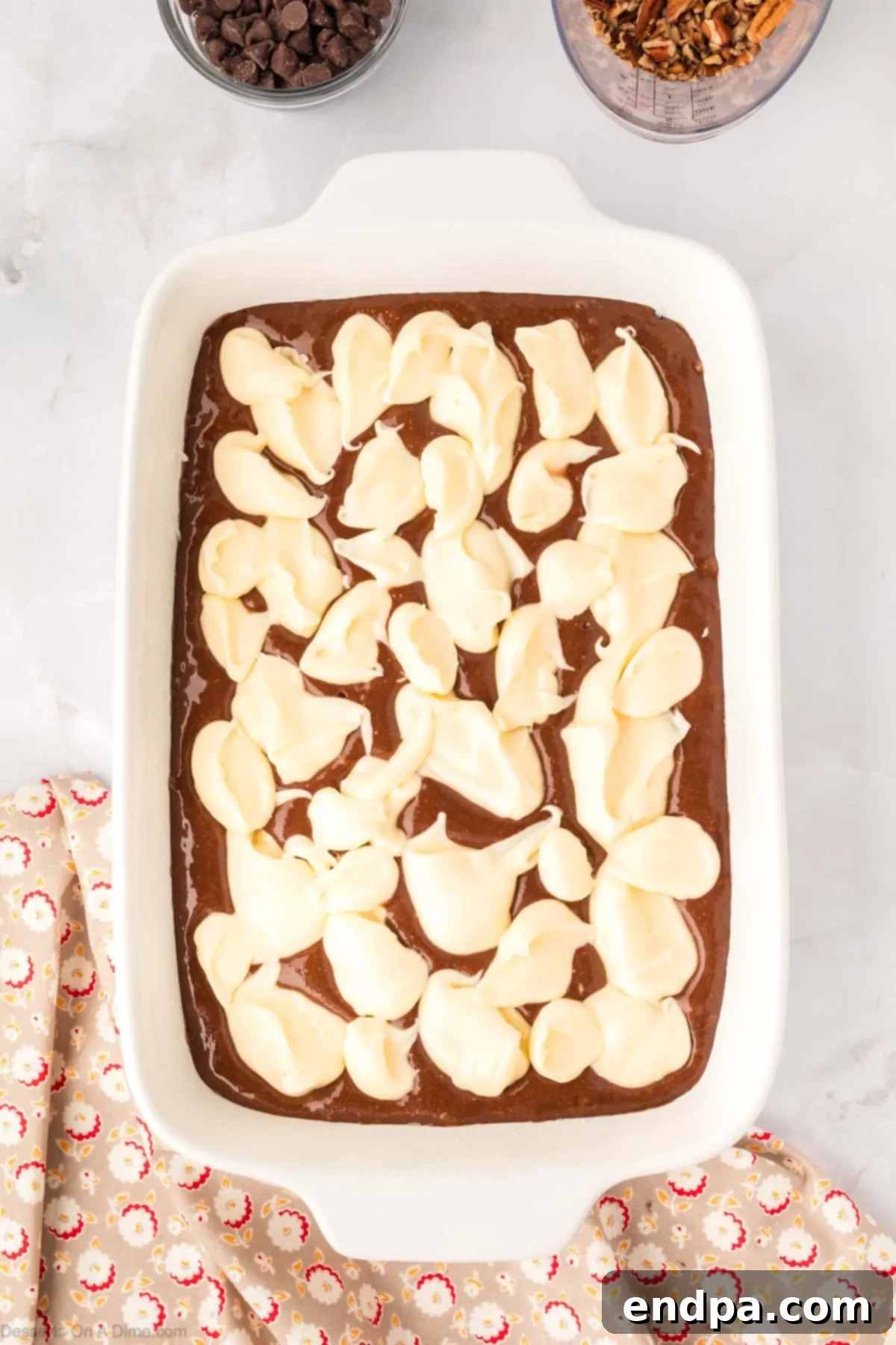 One-Pan German Chocolate Cake 9 Dollops of the cream cheese mixture spread over the cake batter in the baking pan.