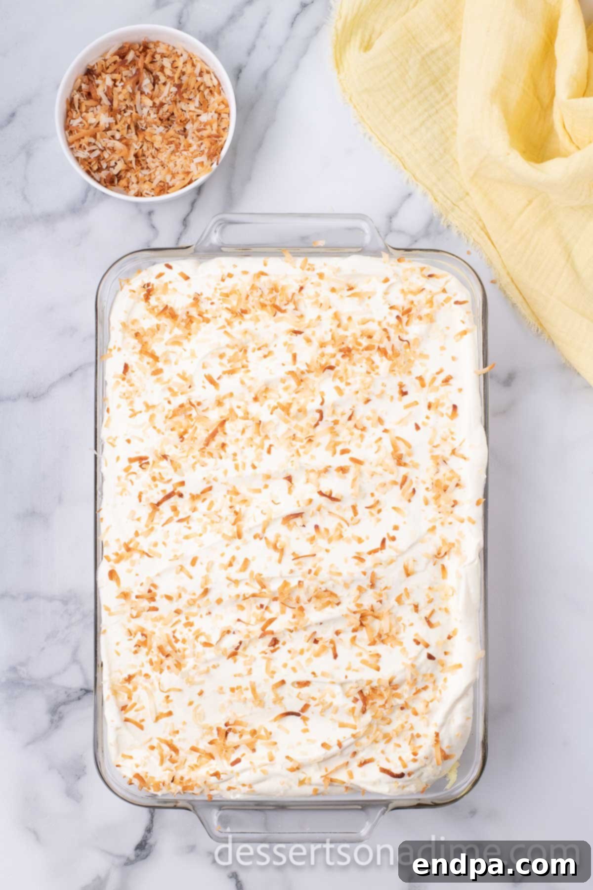 A generous amount of golden toasted shredded coconut beautifully sprinkled over the entire cake, completing its tropical look and adding a delightful crunch.