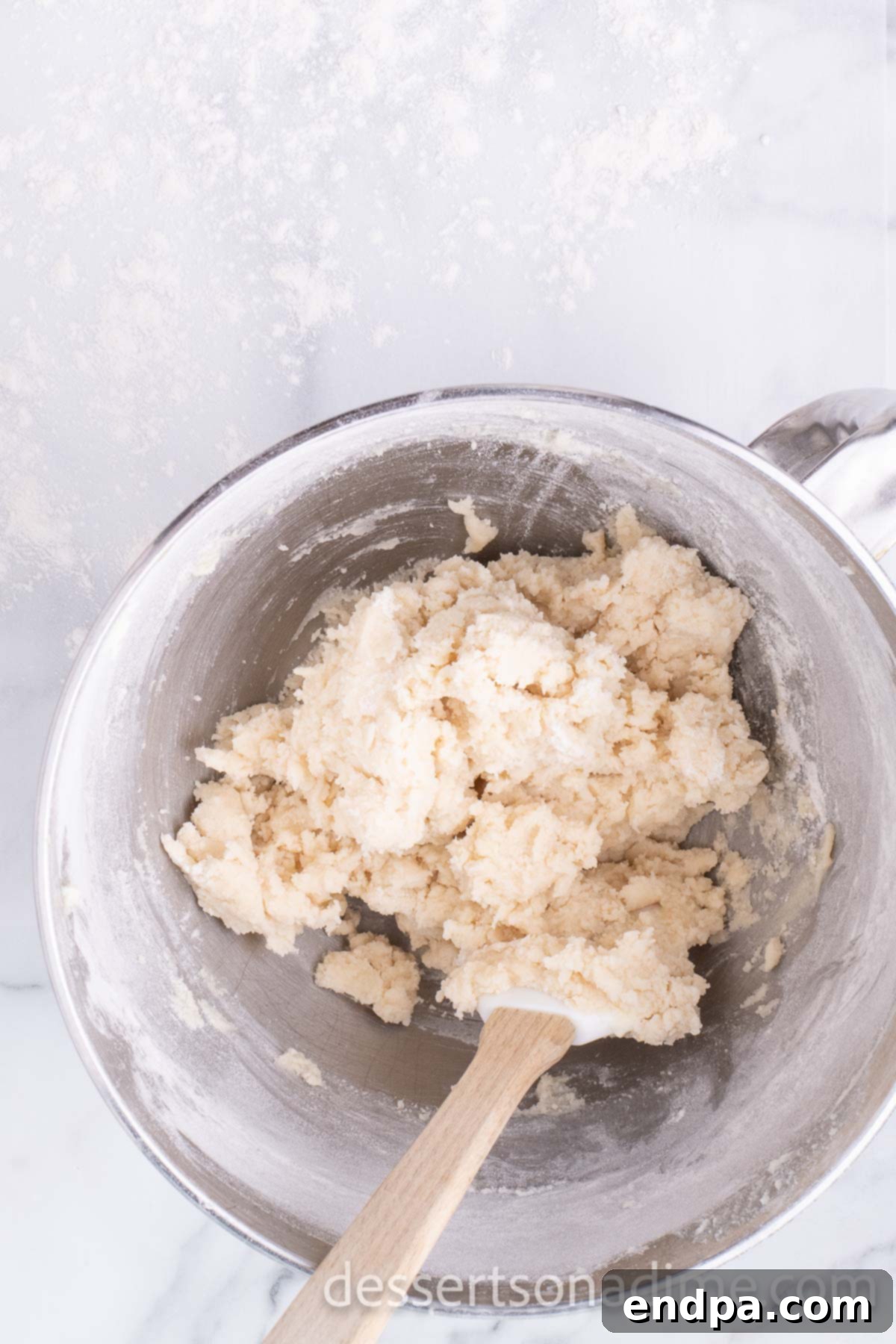 Flour and butter mixture partially combined in a mixing bowl.
