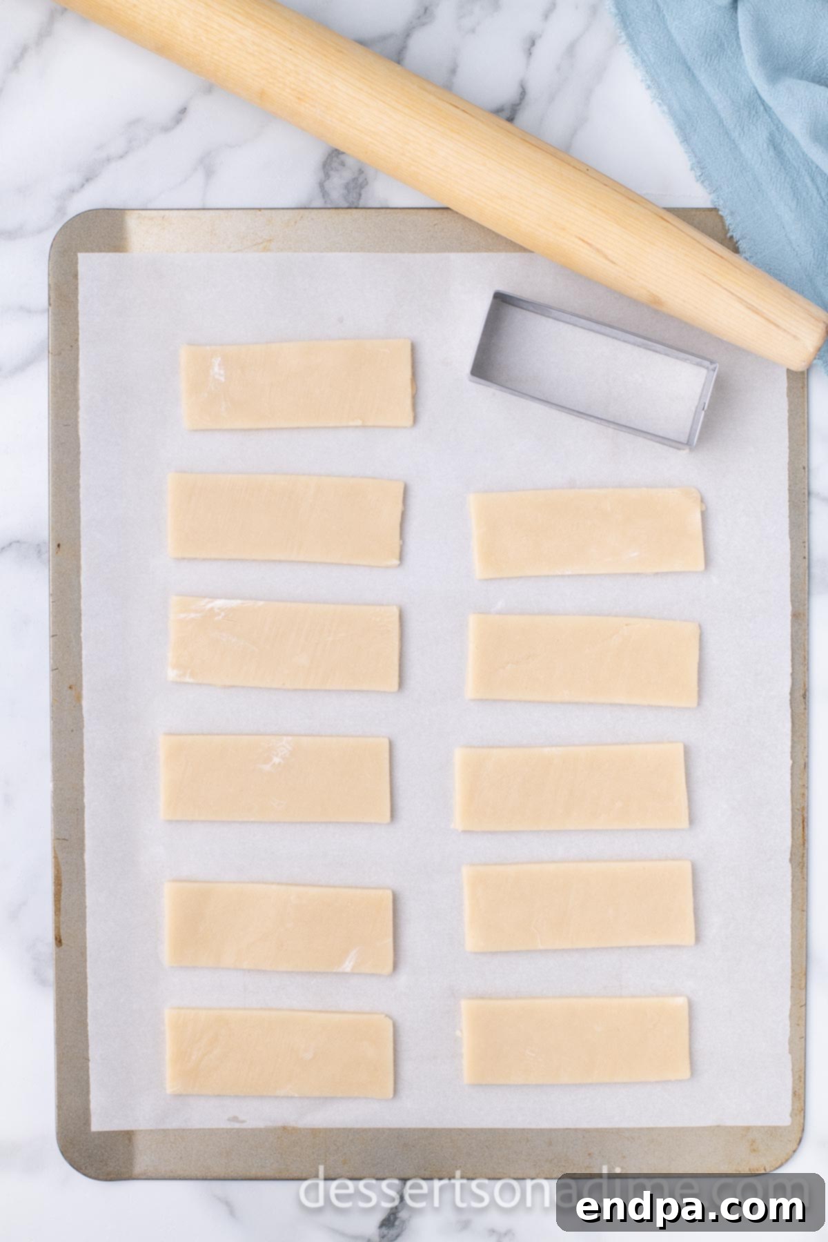 Unbaked shortbread cookies arranged on a parchment-lined baking sheet.