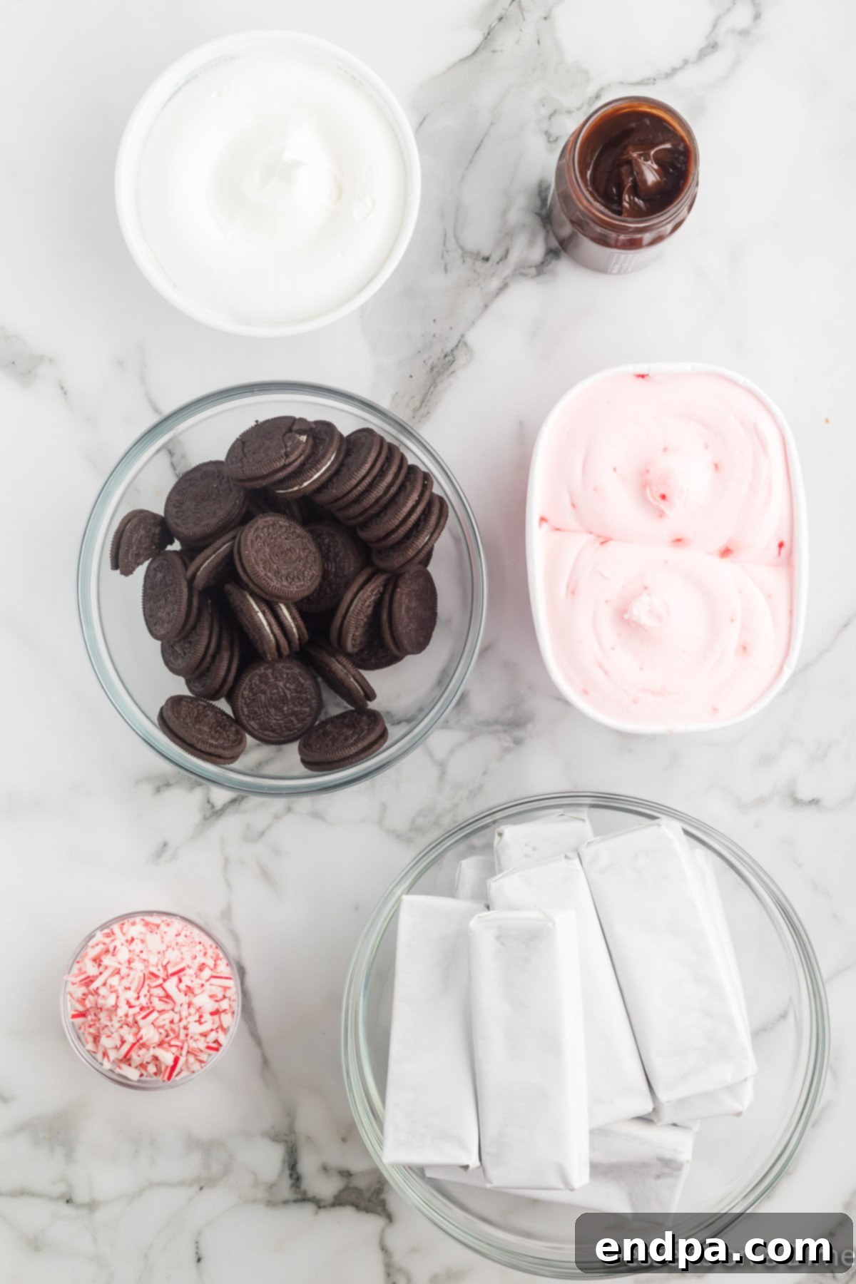 Holly Jolly Ice Cream Cake 3 Ingredients for Christmas ice cream cake, including peppermint ice cream, Oreo cookies, ice cream sandwiches, and candy canes.