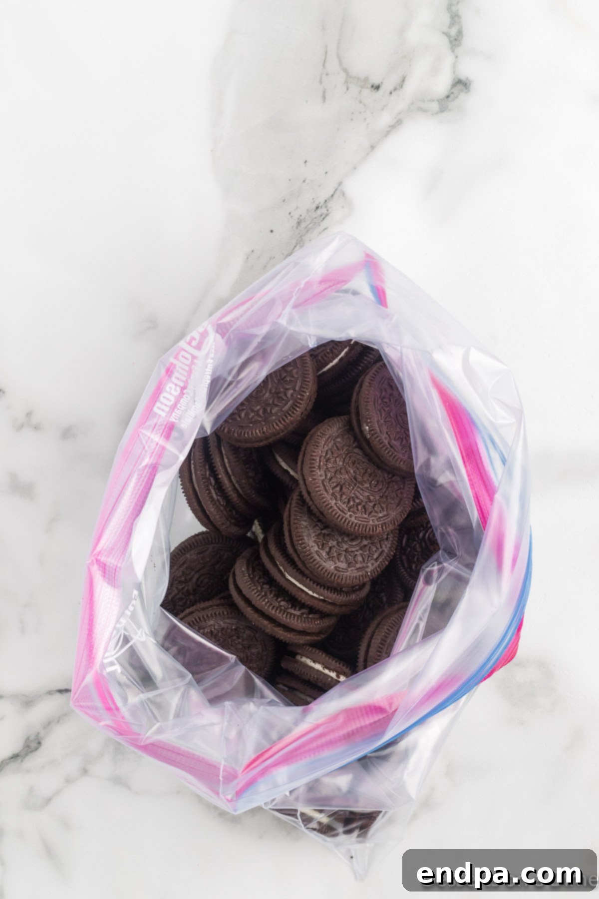Holly Jolly Ice Cream Cake 4 Oreo cookies in a resealable plastic bag, ready to be crushed.