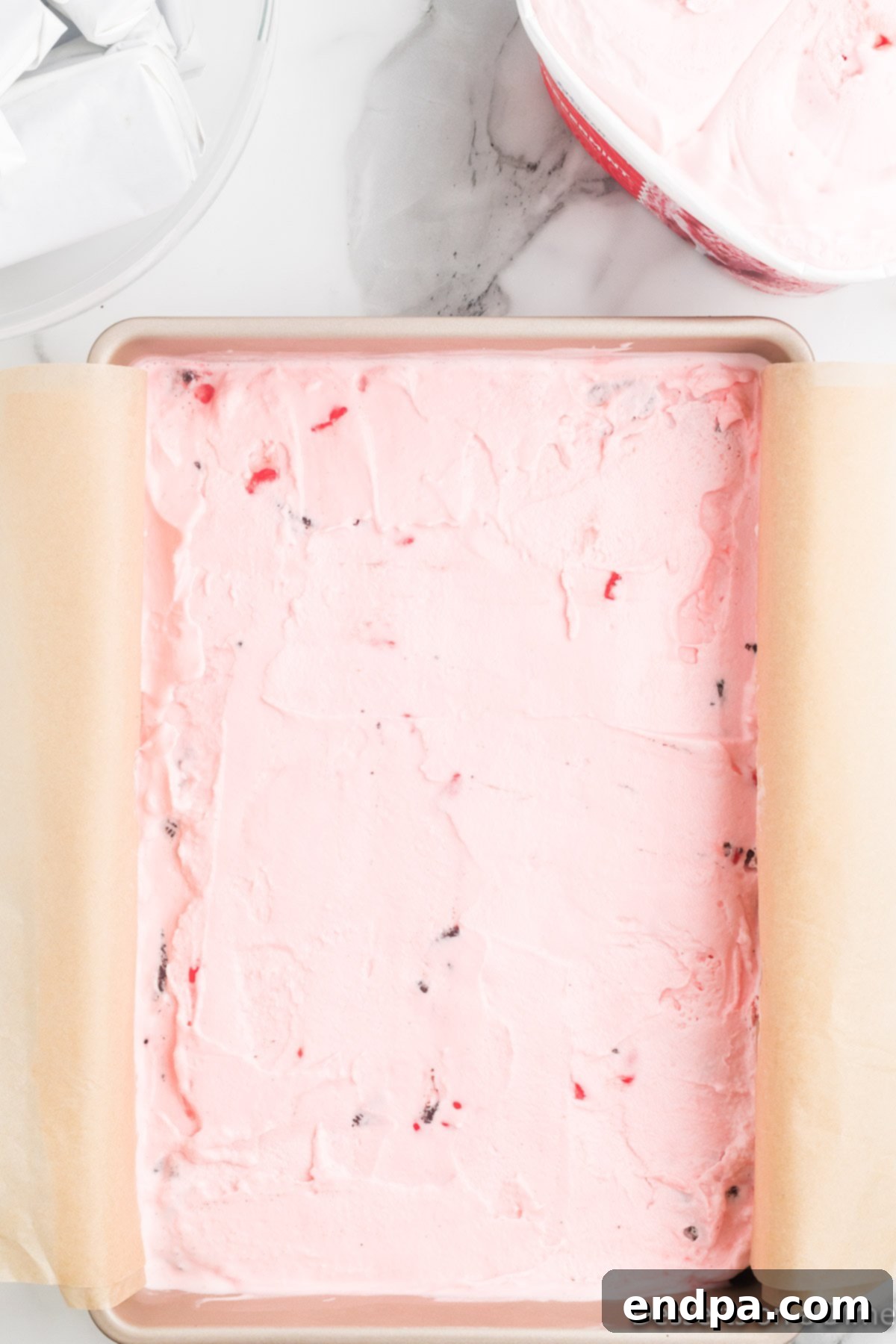 Holly Jolly Ice Cream Cake 7 First layer of peppermint ice cream spread over the crushed Oreos in the pan.