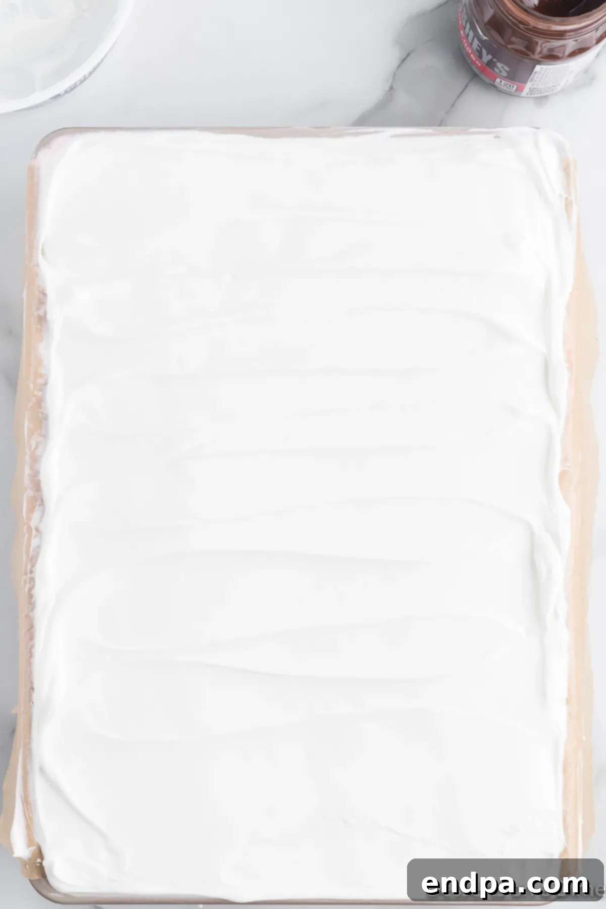 Holly Jolly Ice Cream Cake 10 Whipped cream spread over the top of the ice cream cake.