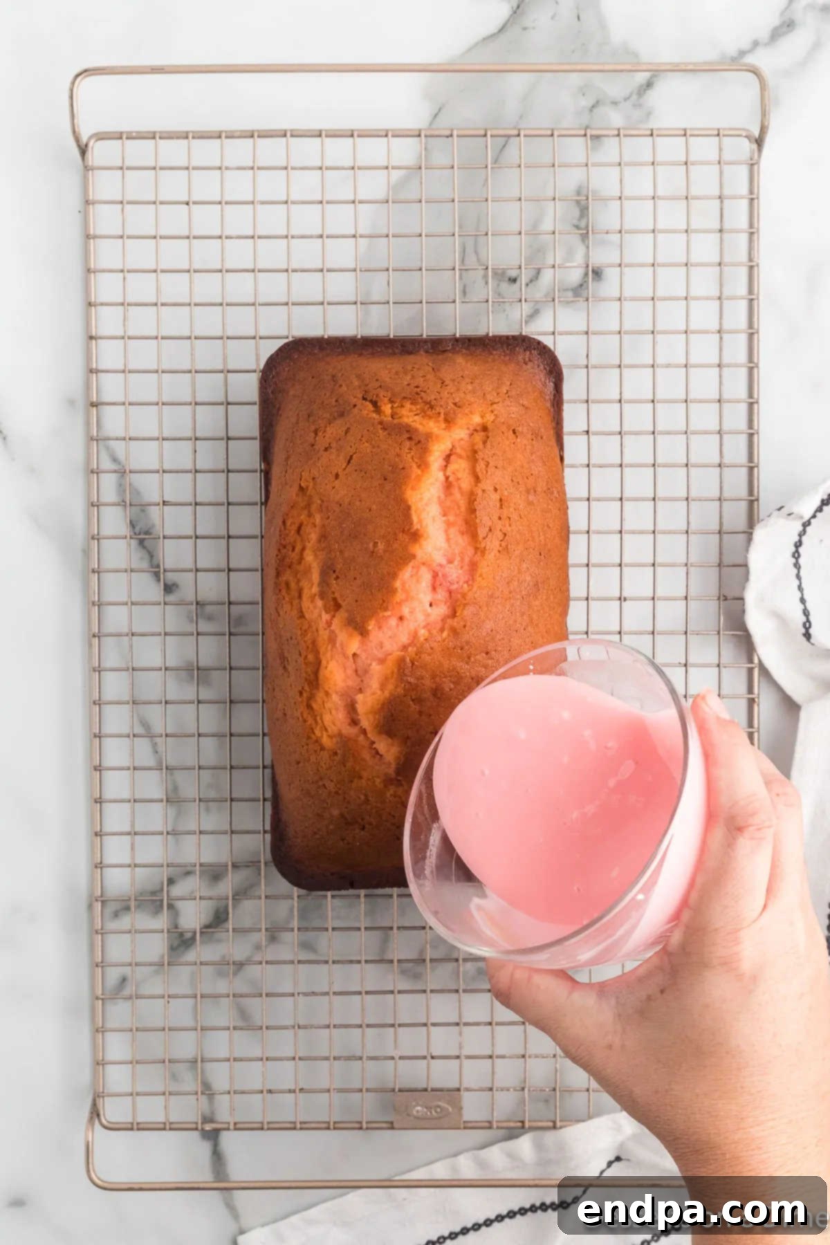 Almond glaze being generously poured over a cooled loaf of Cherry Bread.