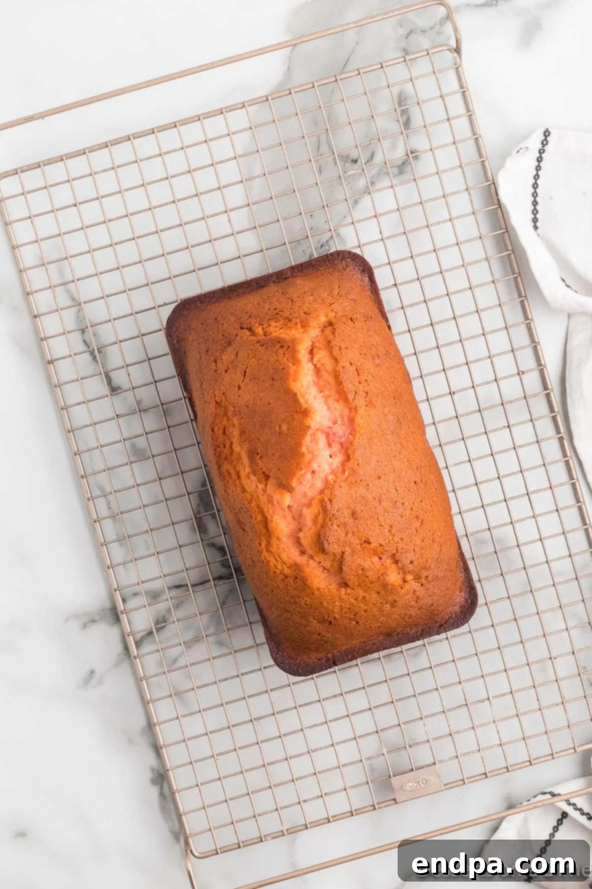 Freshly baked loaf of Cherry Bread cooling on a wire rack.
