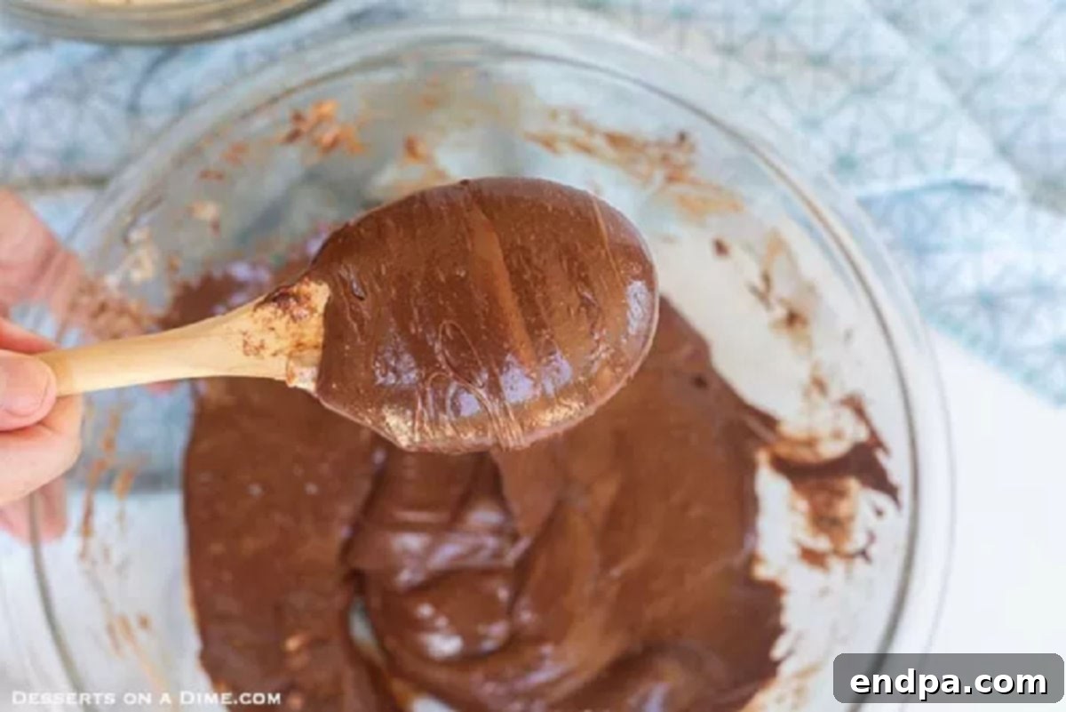 Melted butter, marshmallows, chocolate chips, and cocoa powder mixed in a microwave-safe bowl.