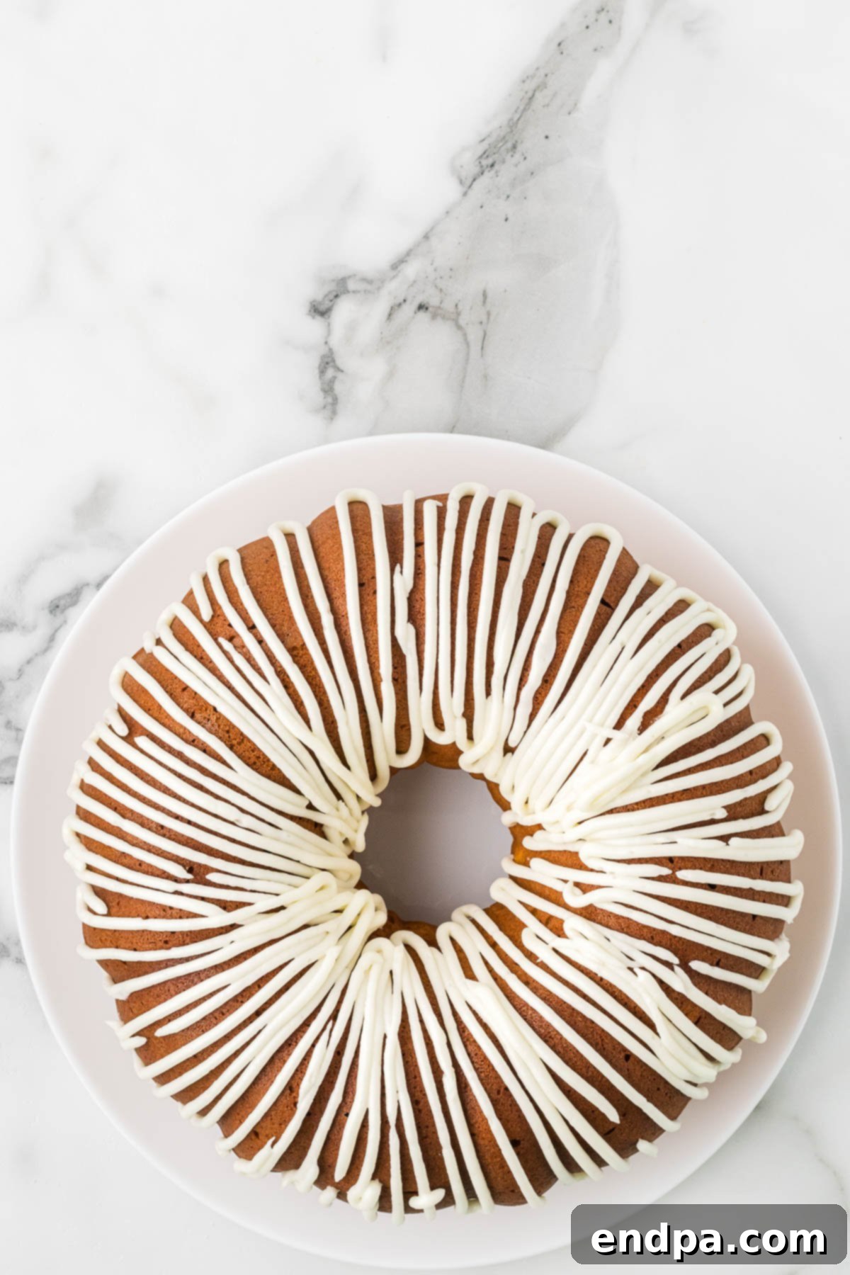 Full Pumpkin Bundt Cake, generously frosted and ready to serve.