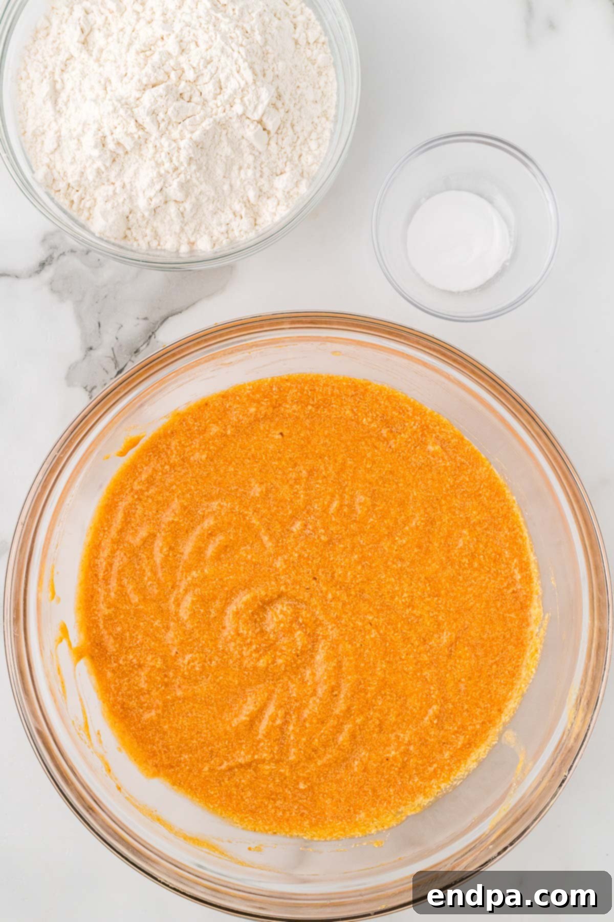 Mixing bowl with pumpkin puree and milk combined into the wet ingredients.