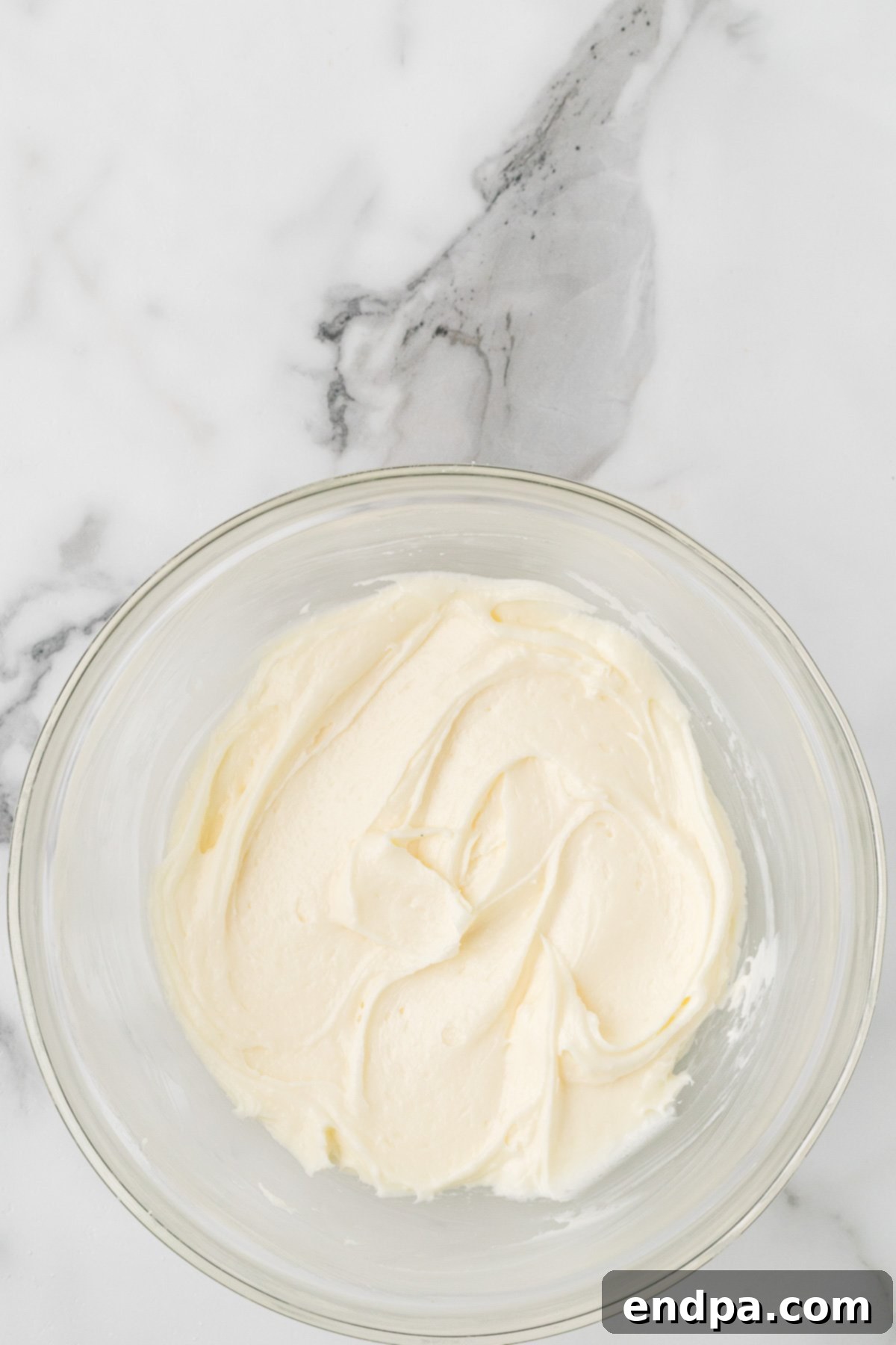 Cream cheese and powdered sugar combined in a bowl for frosting.