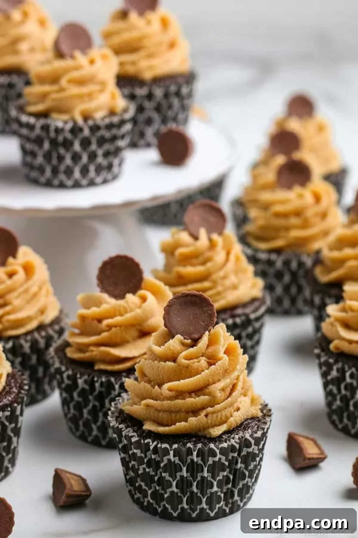 Decadent Chocolate Peanut Butter Cupcakes topped with miniature Reese's Peanut Butter Cups, showcasing their moist chocolate cake and creamy peanut butter frosting.