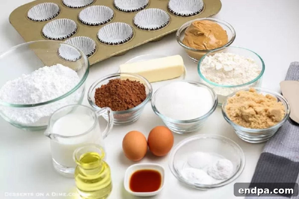 All the necessary ingredients laid out for baking Chocolate Peanut Butter Cupcakes, including brown sugar, flour, cocoa powder, eggs, milk, oil, vanilla extract, butter, peanut butter, and powdered sugar.