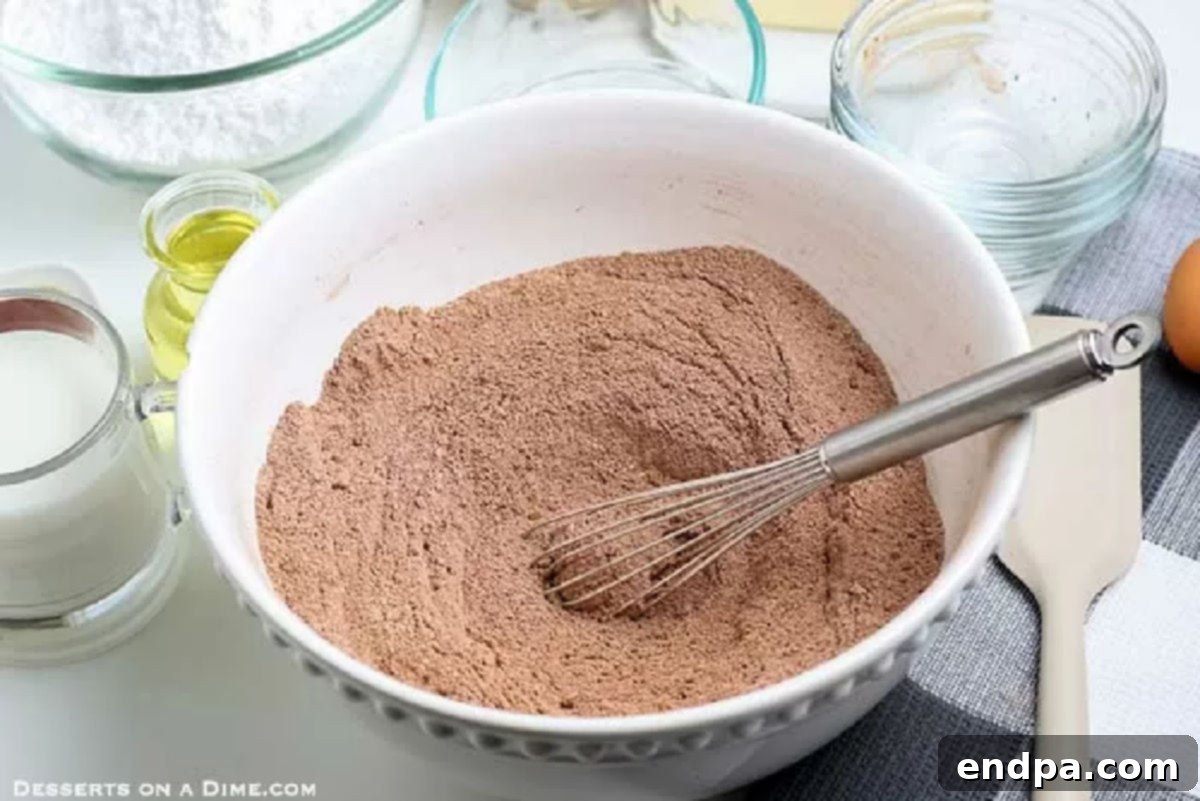 Dry ingredients like sugar, flour, and cocoa powder are whisked together in a bowl.