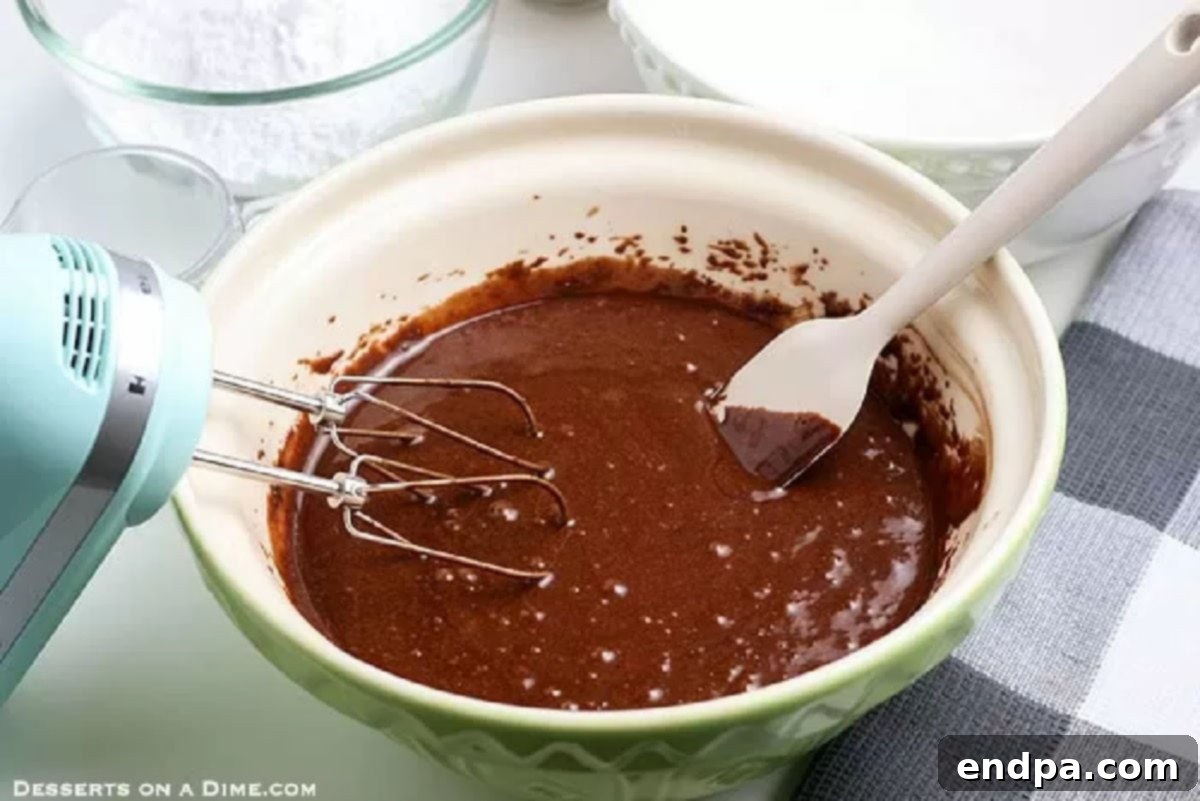Wet ingredients including eggs, milk, oil, and vanilla extract are beaten together in a large mixing bowl.