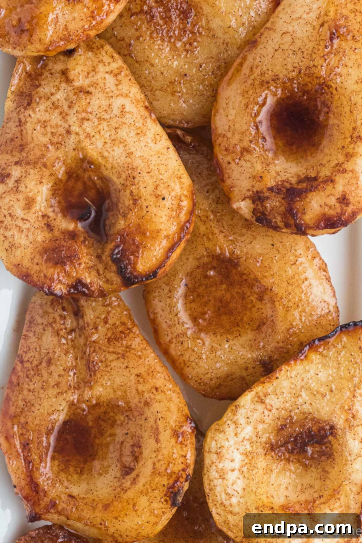 Cooked pear halves, caramelized and tender, arranged appealingly for serving.