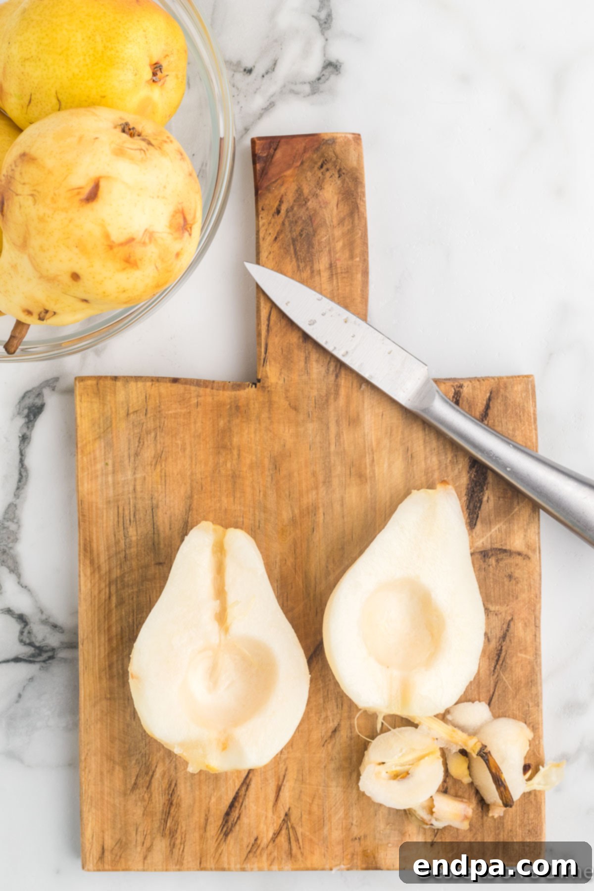 A pear cut in half, showing the core removed.